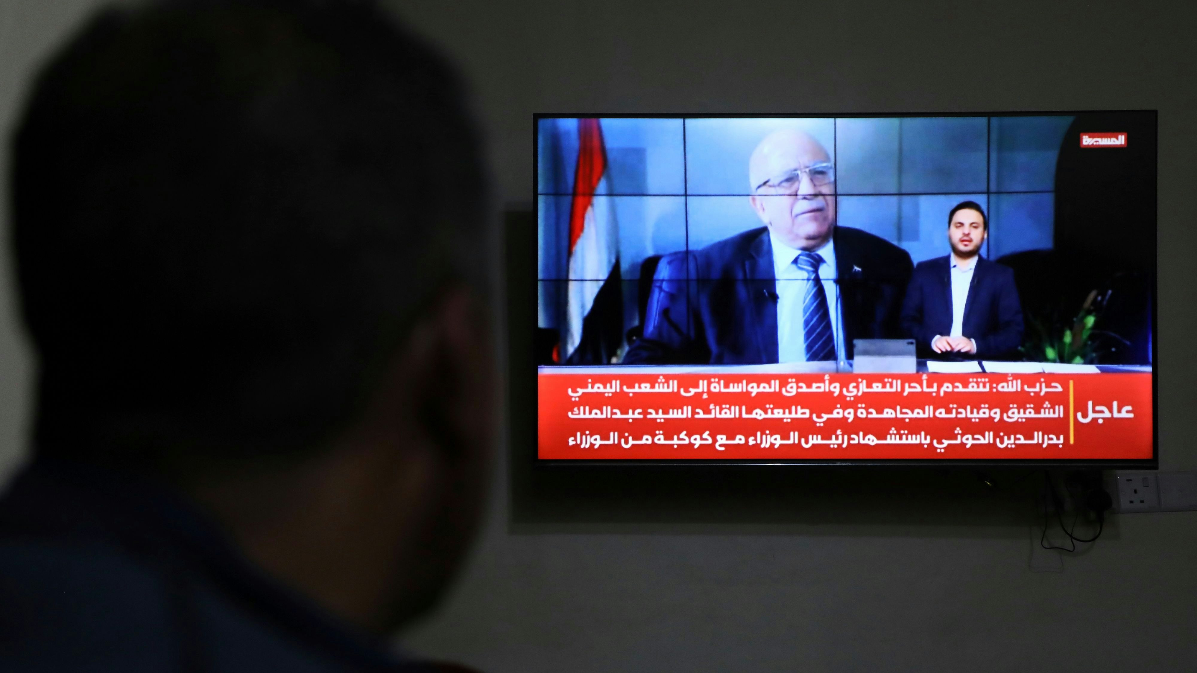 Download von www.picturedesk.com am 30.08.2025 (20:42).  A man watches the news on TV, displaying footage of Ahmed al-Rahawi, the prime minister of the Houthi-controlled government, who was killed, along with others, in Thursday's Israeli strikes on the capital, in Sanaa, Yemen, Saturday, Aug. 30, 2025. (AP Photo/Osamah Abdulrahman) - 20250830_PD14635 - Rechteinfo: Rights Managed (RM)