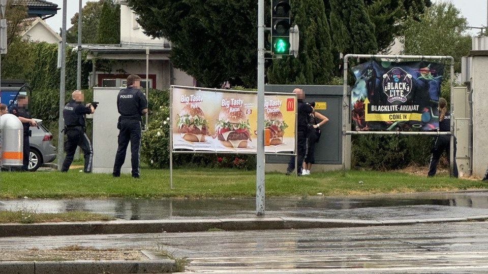 Die Polizisten zielen mit ihren Waffen auf die Messer-Frau.