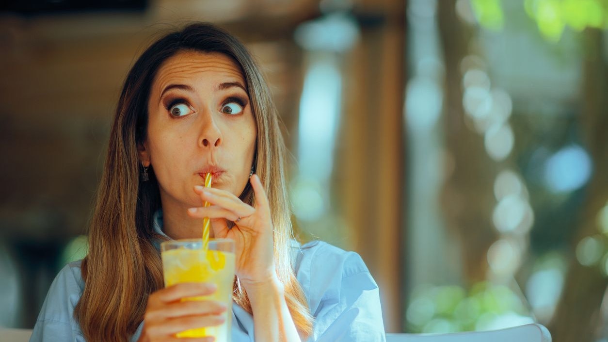 Customer in diner sipping citrus beverage finding it too sour