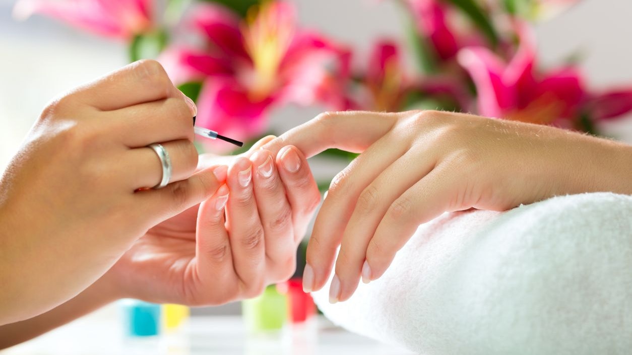 Woman in a nail salon receiving a manicure by a beautician