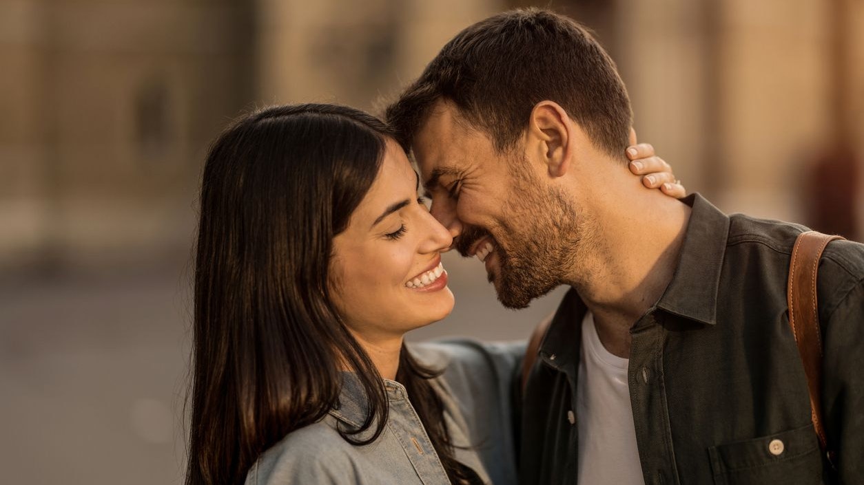 Young couple falling in love while having a walk in the city together on summer day.