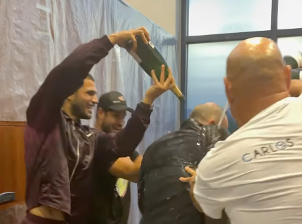 Alcaraz feiert mit Champagner in der Kabine.