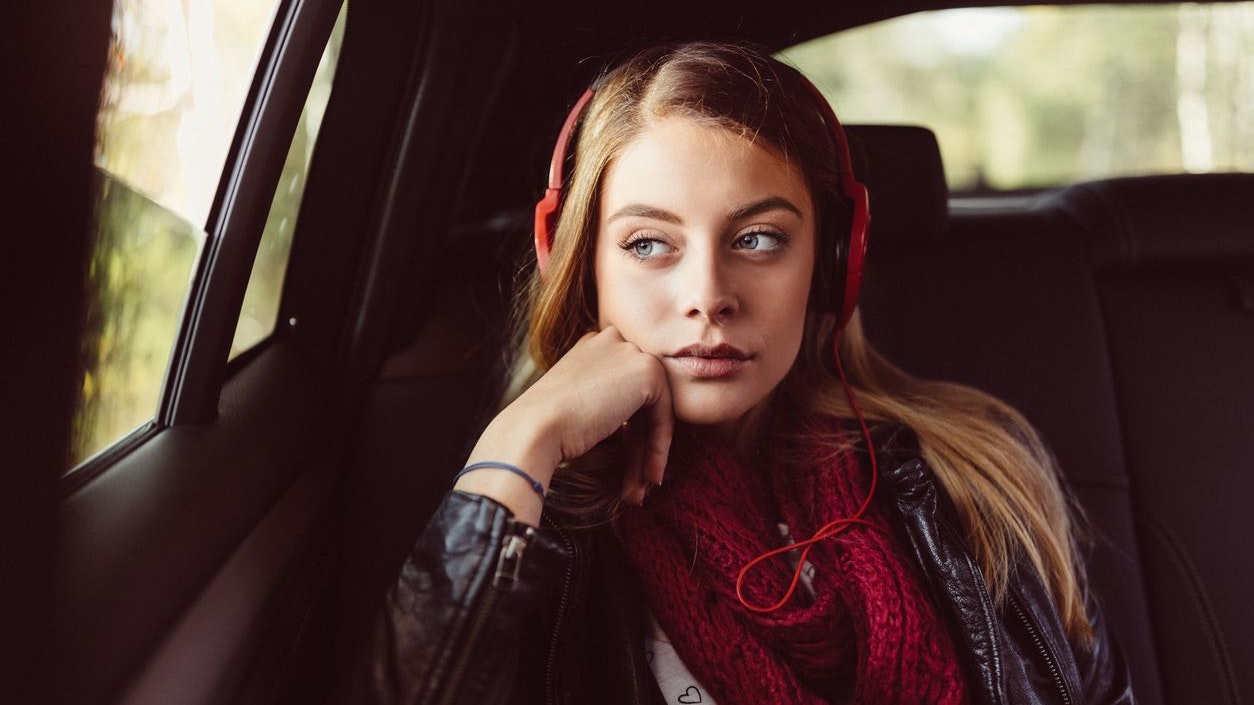 Woman traveling in car and listening to music