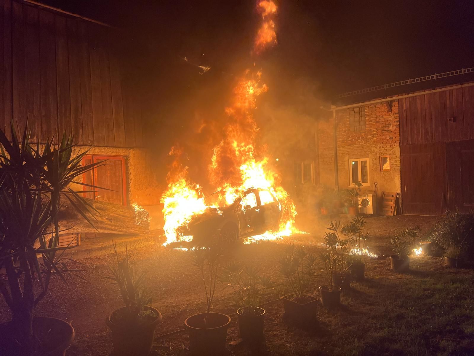 Die Feuerwehrkräfte löschten das brennende Auto, bevor das angrenzende Haus noch mehr Feuer fingen konnte.