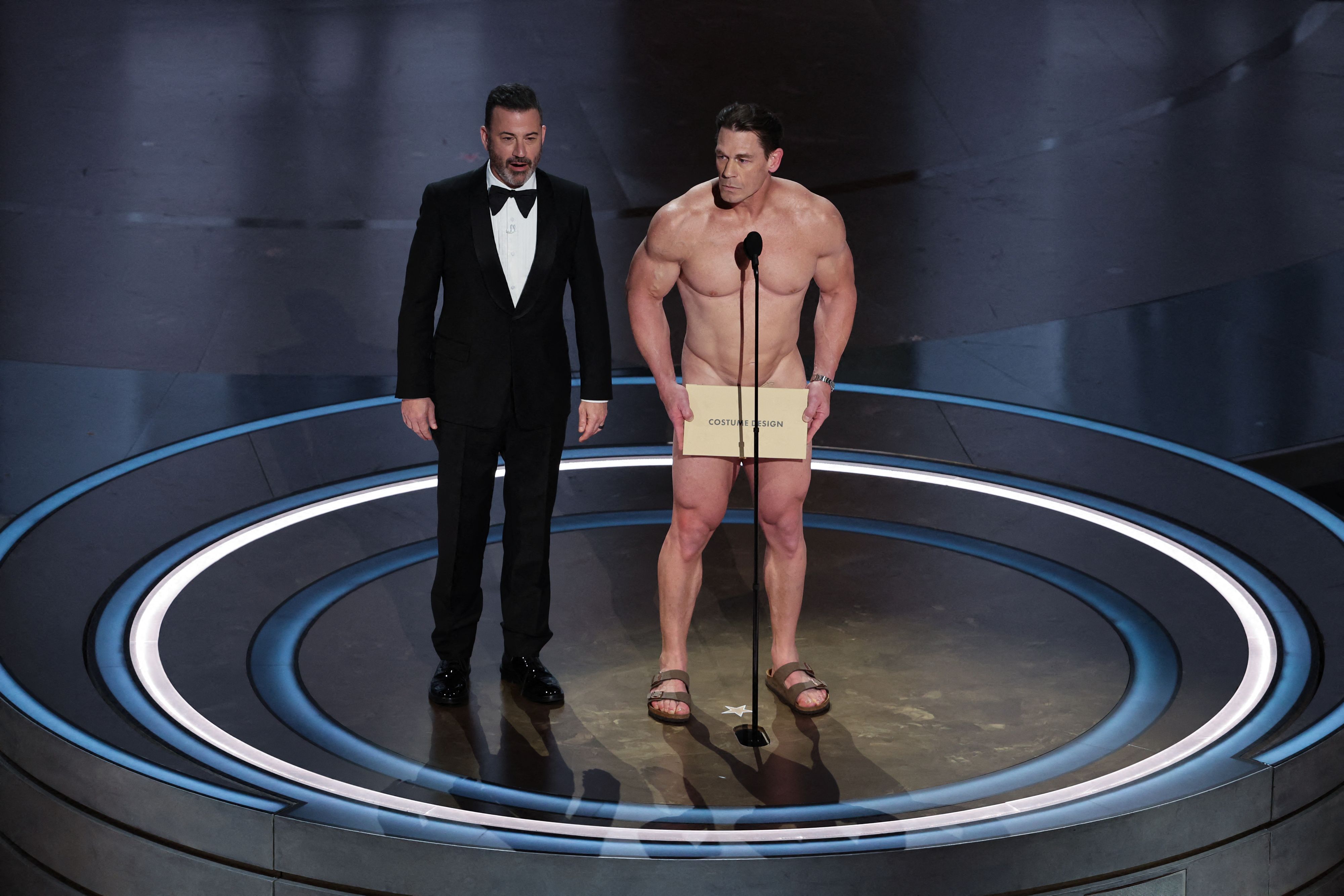 Gag auf der Oscar-Verleihung 2024: John Cena und Gastgeber Jimmy Kimmel geben die Preisträgerin für das Kostüm-Design bekannt