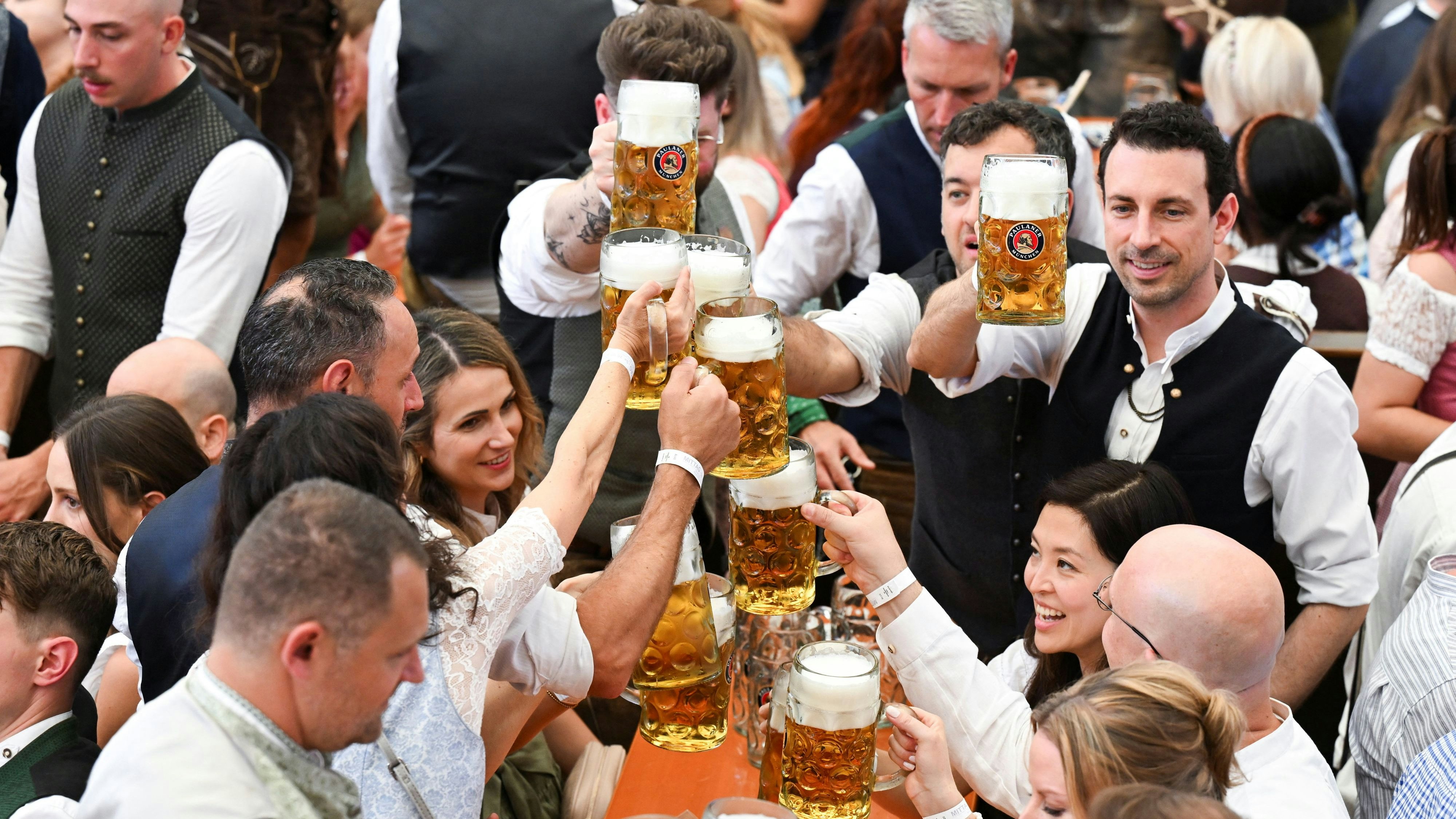 Visitors raise their beer mugs during the official opening day of the 190th Oktoberfest, the world's largest beer festival in Munich, Germany, September 20, 2025. REUTERS/Angelika Warmuth
