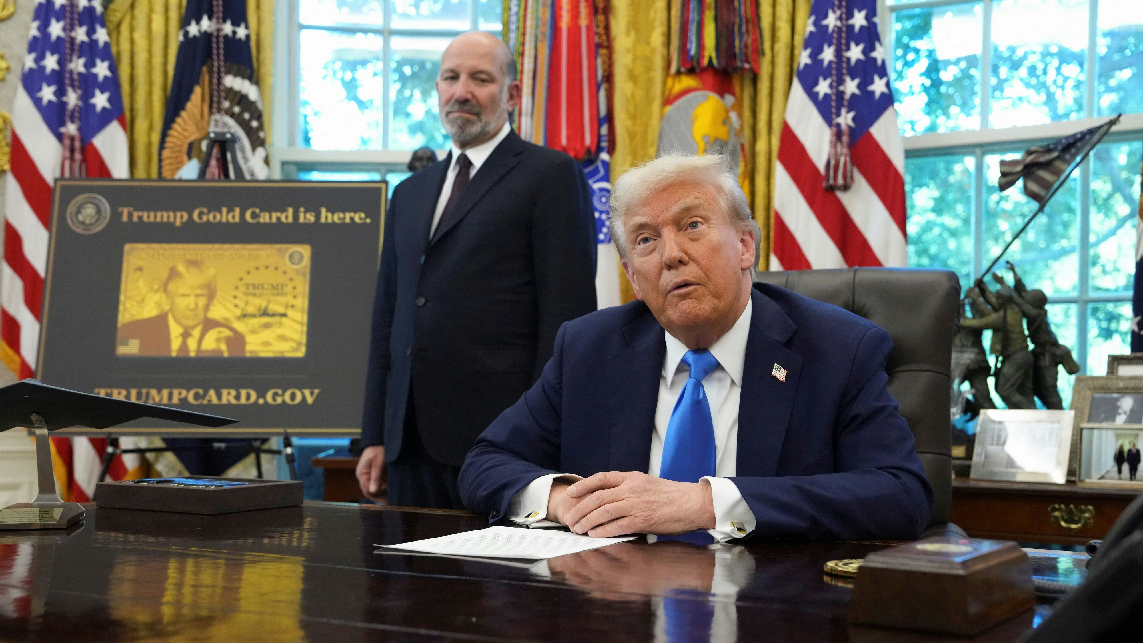 U.S. President Donald Trump speaks, with U.S. Secretary of Commerce Howard Lutnick standing by his side as a sign that reads "Trump Gold Card is here" is displayed, in the Oval Office at the White House in Washington, D.C., U.S., September 19, 2025. REUTERS/Ken Cedeno 