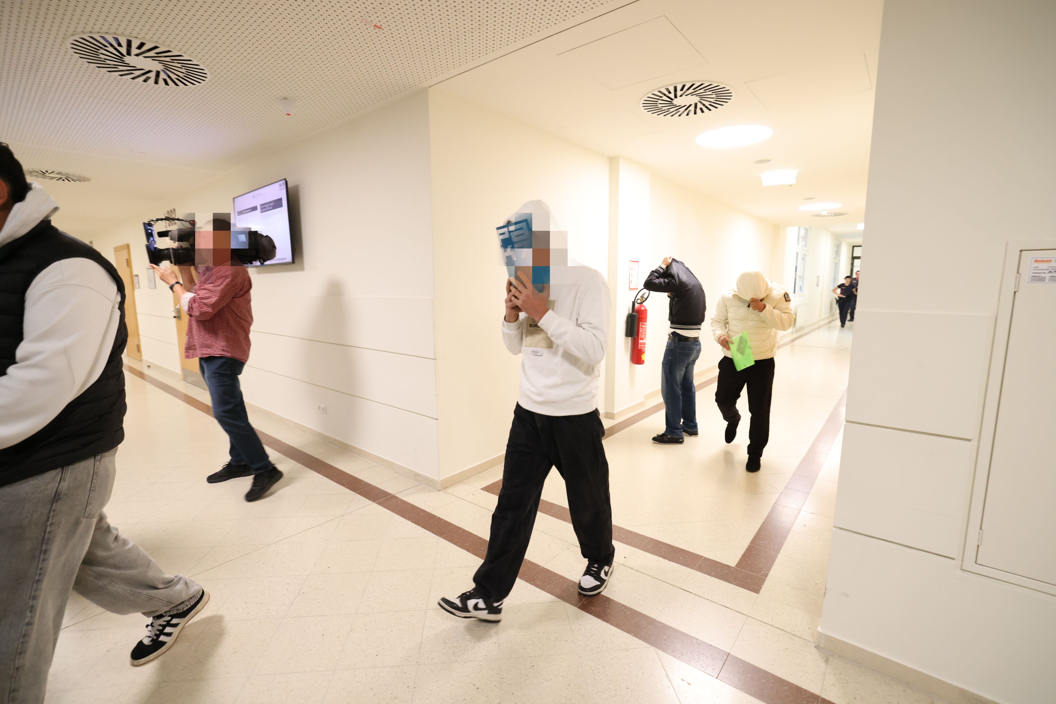 Angeklagte am Wiener Landesgericht: Die meisten verhüllten beim Prozessauftakt ihre Gesichter.