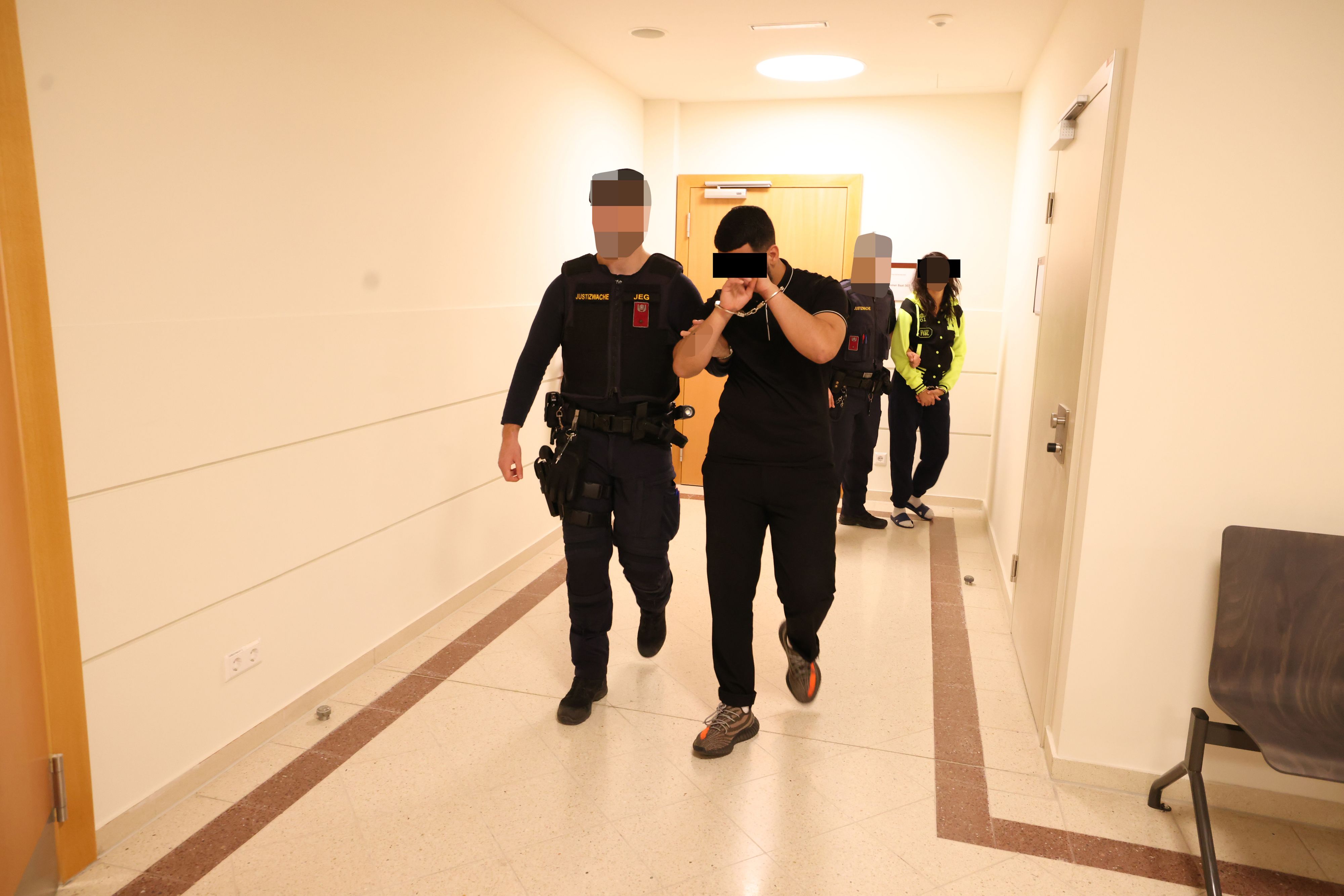 Der Angeklagte vor Gericht, im Hintergrund die Zeugin. Sie ist ebenfalls im Gefängnis.