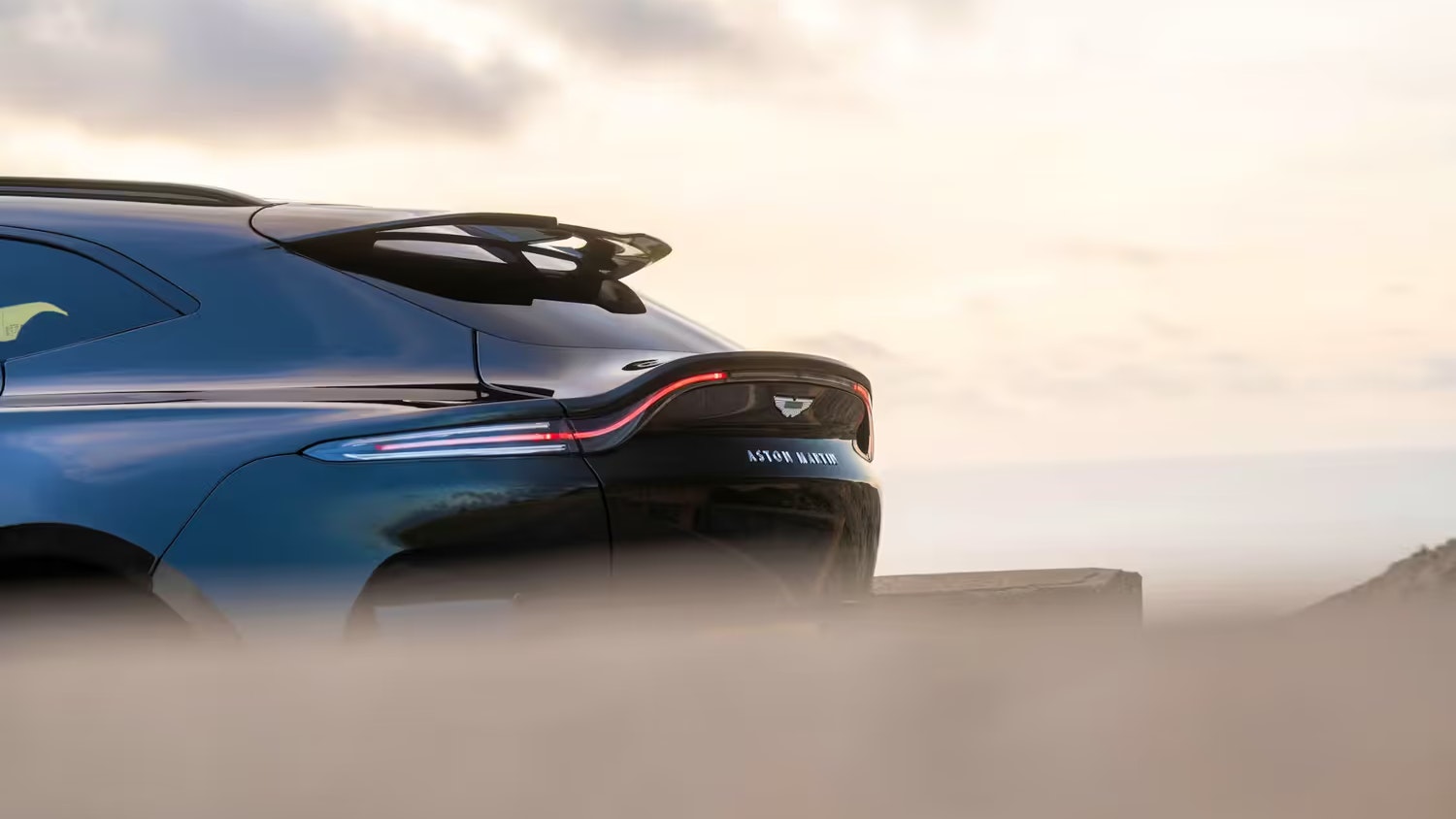 Eleganz bis ins Detail: Das geschwungene Heck mit den vier Endrohren unterstreicht die sportliche DNA – britischer Luxus im Sonnenuntergang.