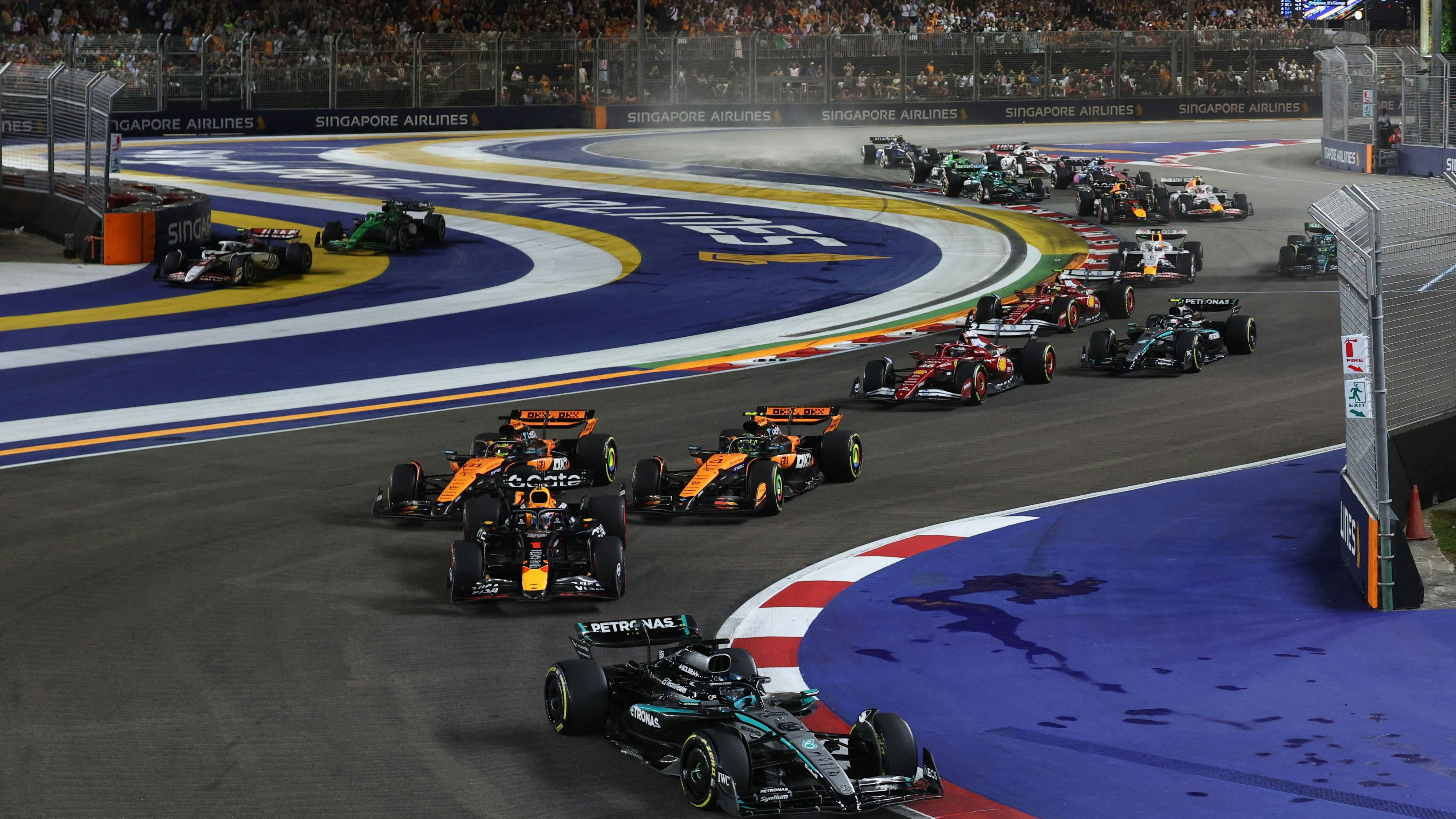 Nach dem Start kommt es zwischen den McLarens in "Papaya" fast zum Crash.