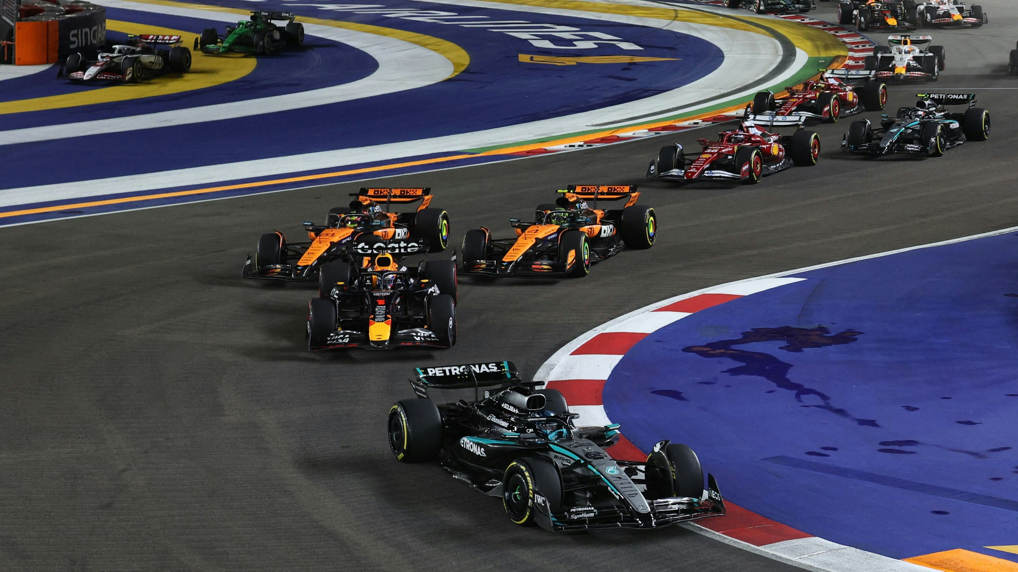 Nach dem Start kommt es zwischen den McLarens in "Papaya" fast zum Crash.