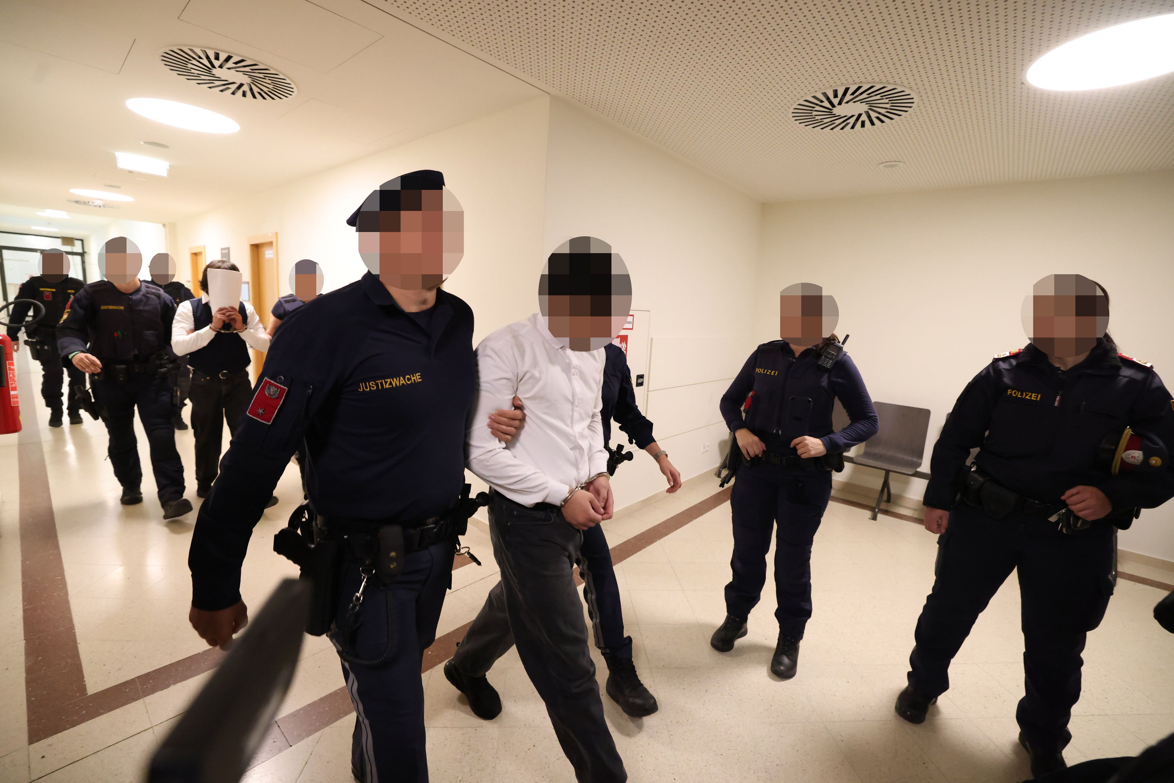 Großes Aufgebot an Justiz-Wachebeamten: Die Angeklagten werden in den Gerichtssaal geführt.