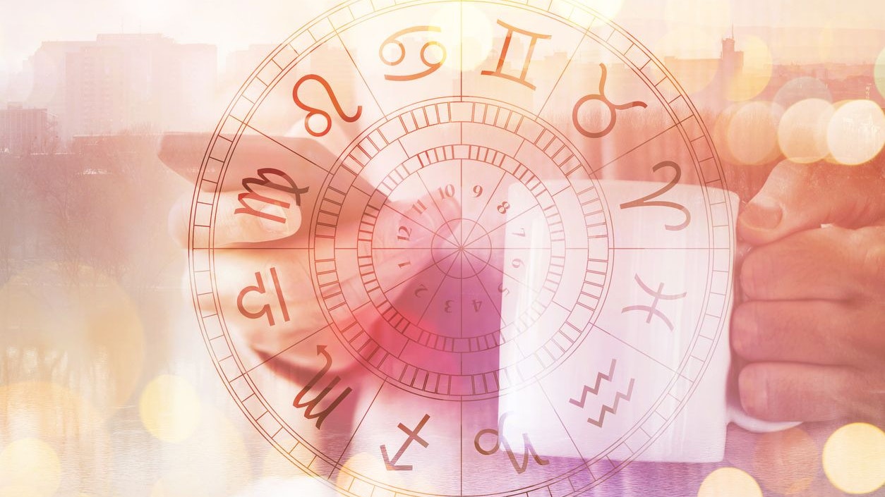 Astrology smartphone app, man drinking coffee and reading horoscope and astrological predictions on mobile phone, selective focus