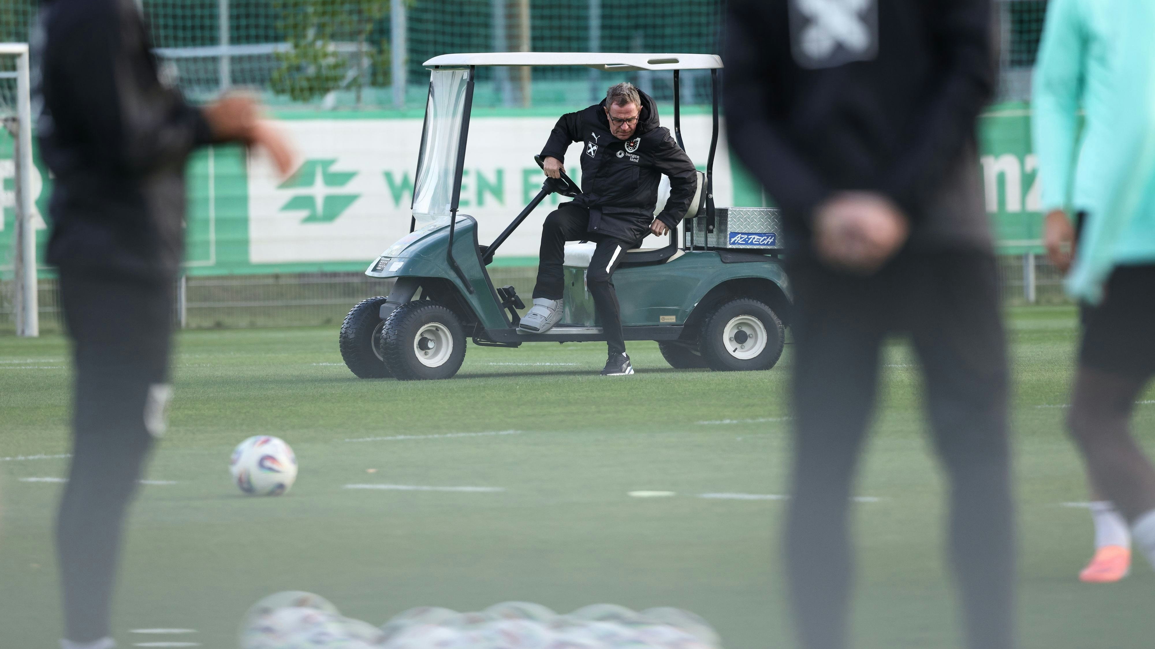 Teamchef Rangnick steigt mit seiner Schiene am rechten Fuß aus dem Golfcart.