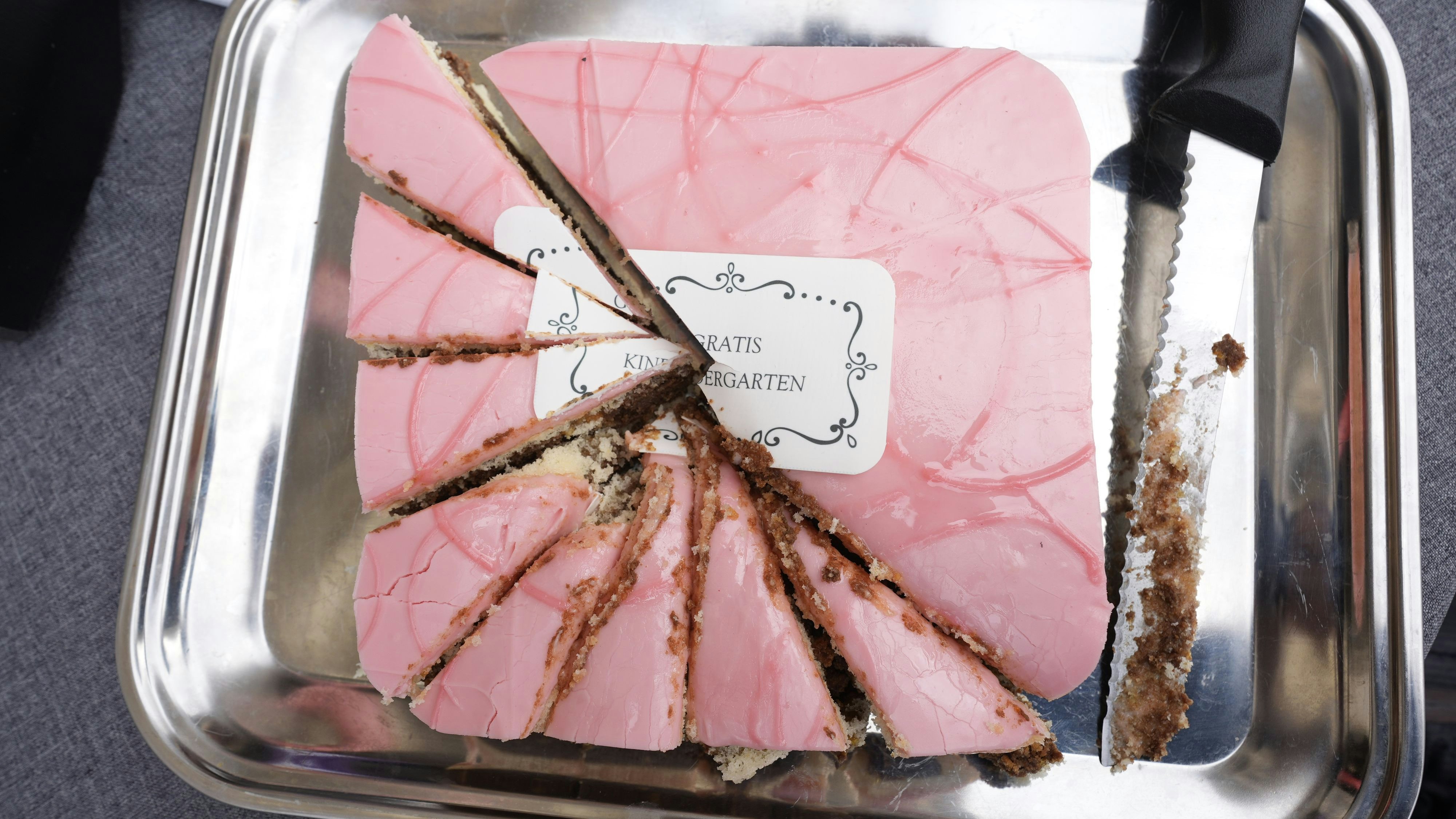 Symbolischer Schnitt: Der Punschkrapfen mit der Aufschrift "Gratis-Kindergarten" wurde bei der Grünen-Demo vor dem Rathaus zerteilt.