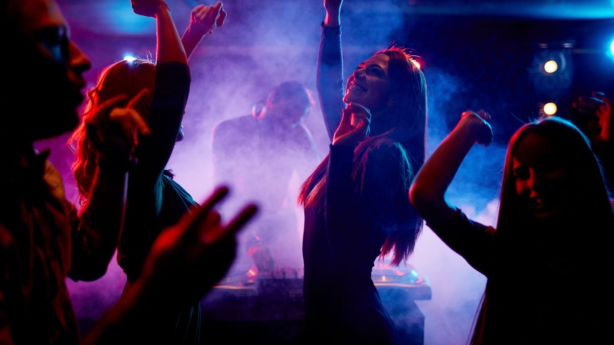 Group of dancing young people enjoying night in club
