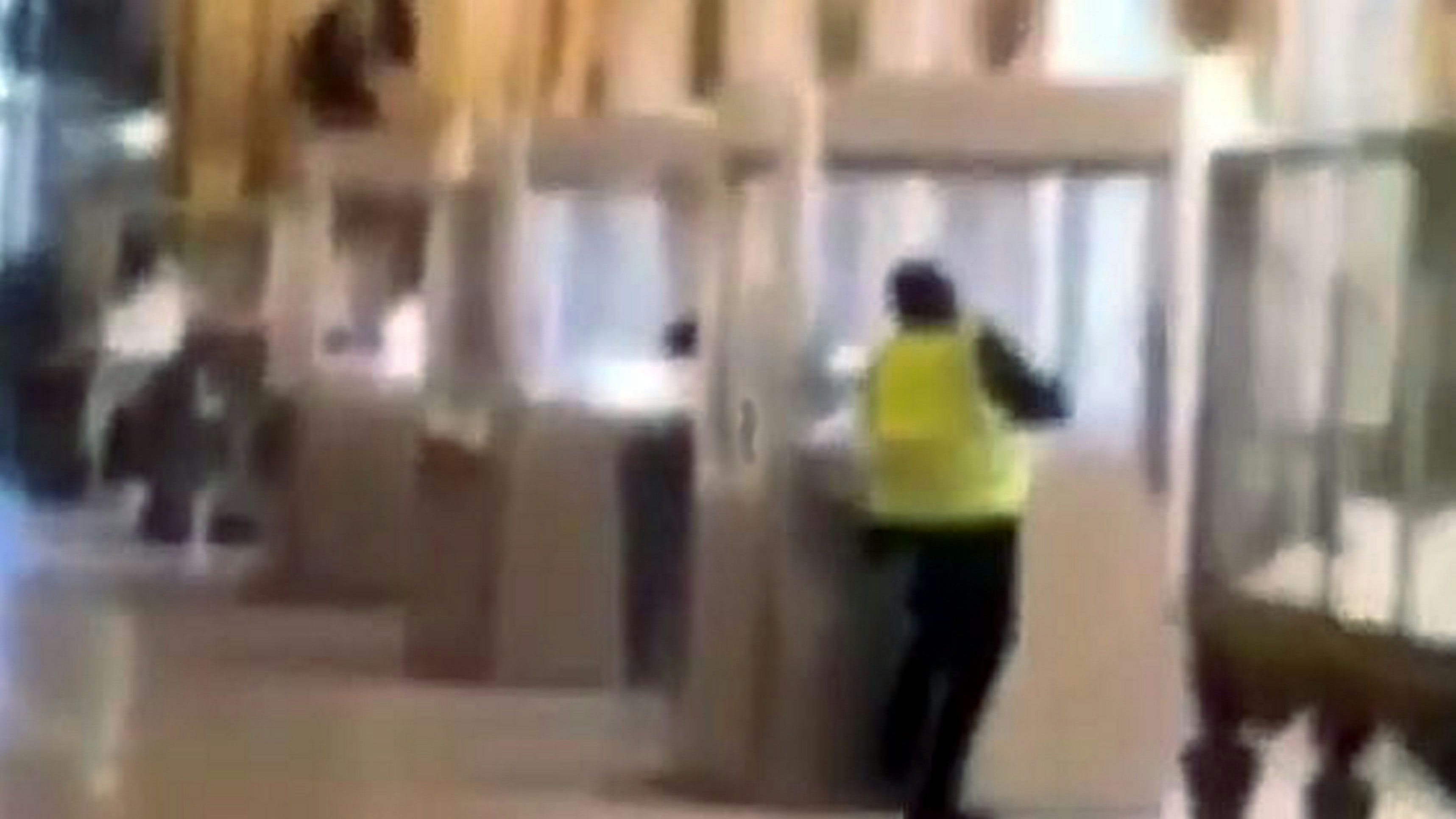 Einer der beiden Räuber an der Arbeit im Napoleon-Saal, gefilmt von einem Besucher. Der Täter flext eine Vitrine auf