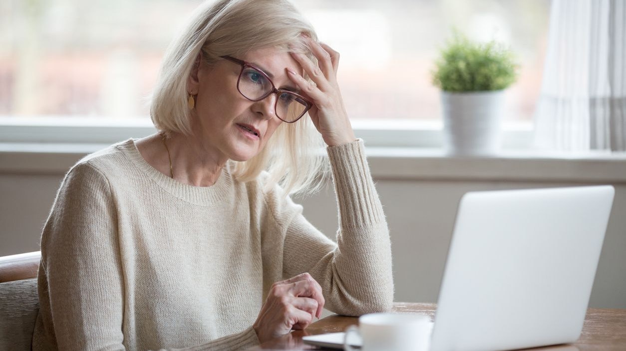 Thoughtful confused mature business woman concerned thinking about online problem looking at laptop, frustrated worried senior middle aged female reading bad email news, suffering from memory loss