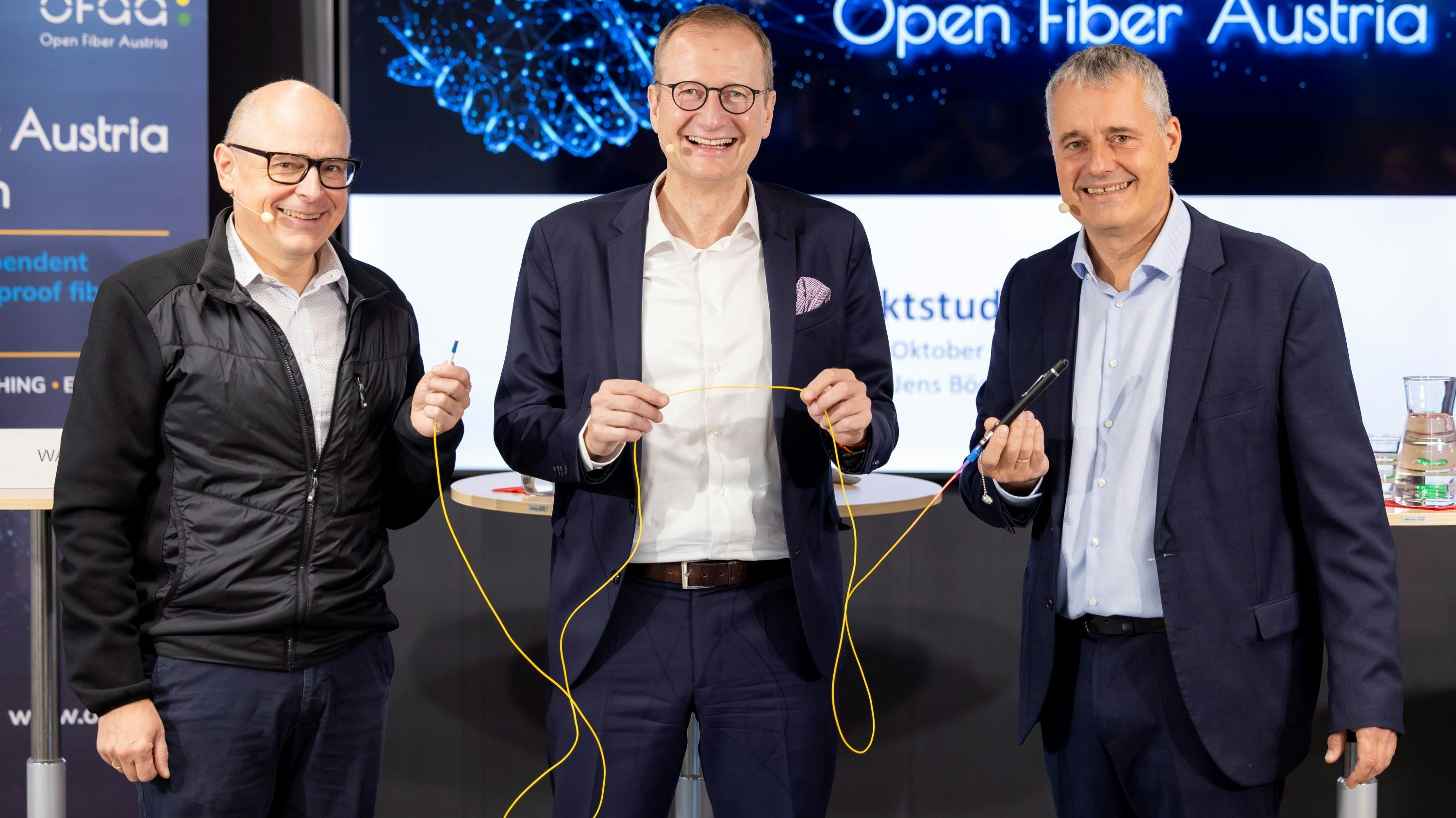 Vom Strom zum Licht: vl: Martin Wachutka, Prof. Jens Böcker und Herbert Flatscher demonstrieren anhand eines Glasfaserkabels und einer Rotlichtquelle das Grundprinzip der konkurrenzlosen optischen Datenübertragung. 