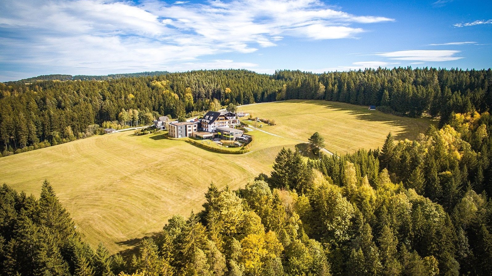 Der Hotel-Komplex Schwarz Alm ist umgeben von dichtem Wald.