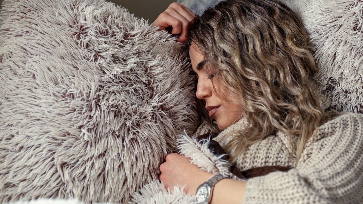 beautiful woman is sleeping and dreaming on soft bed at home