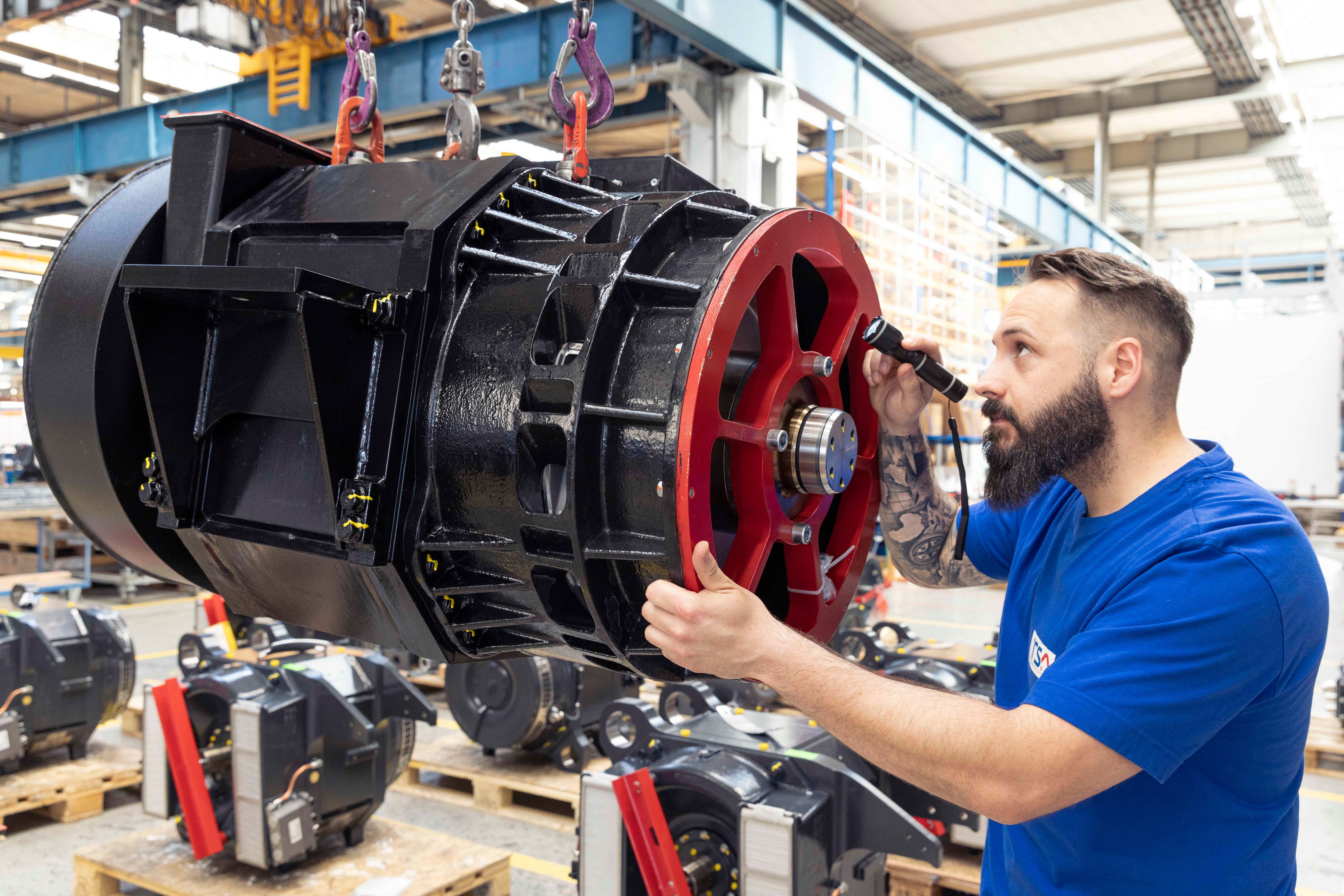 Ein Mitarbeiter der Traktionssysteme Austria GmbH (TSA) bei der Arbeit an einem Elektromotor in der Produktionshalle in Wiener Neudorf.