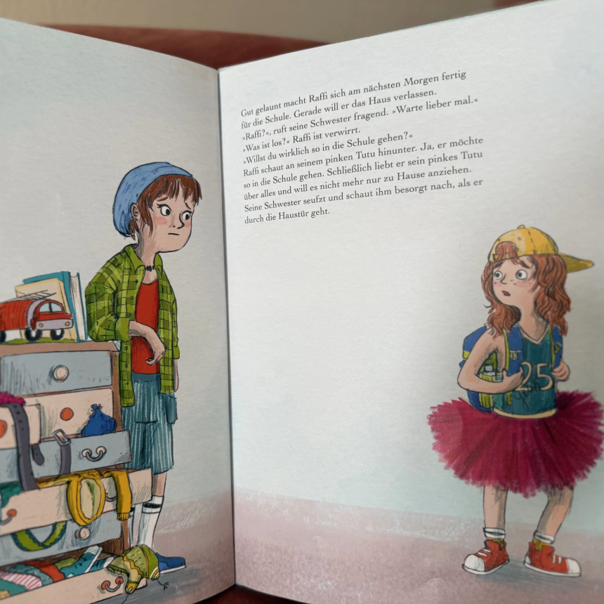 "Raffi schaut an seinem pinken Tutu hinunter" – ein Bild aus einem Kinderbuch.