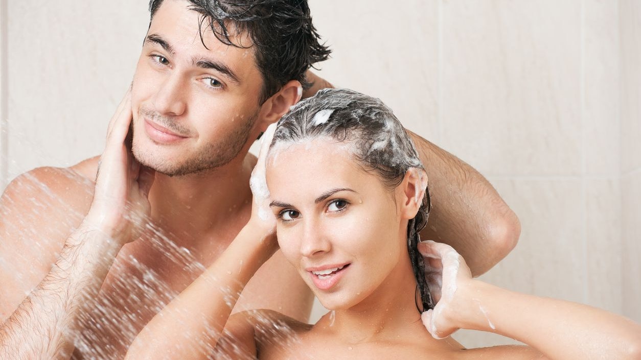 Young couple washing their heads in the shower