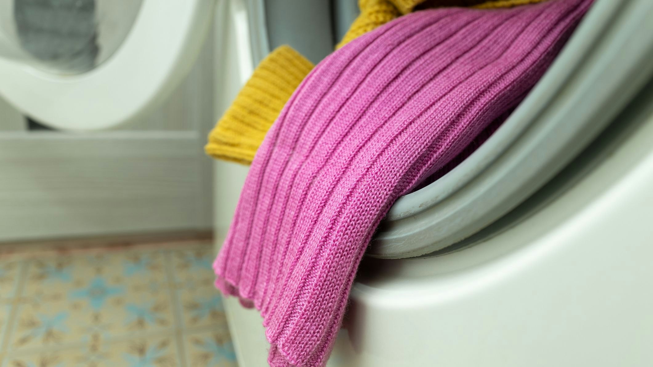 colored clothes sticking out of the washing machine. laundry in the washing machine. High quality photo