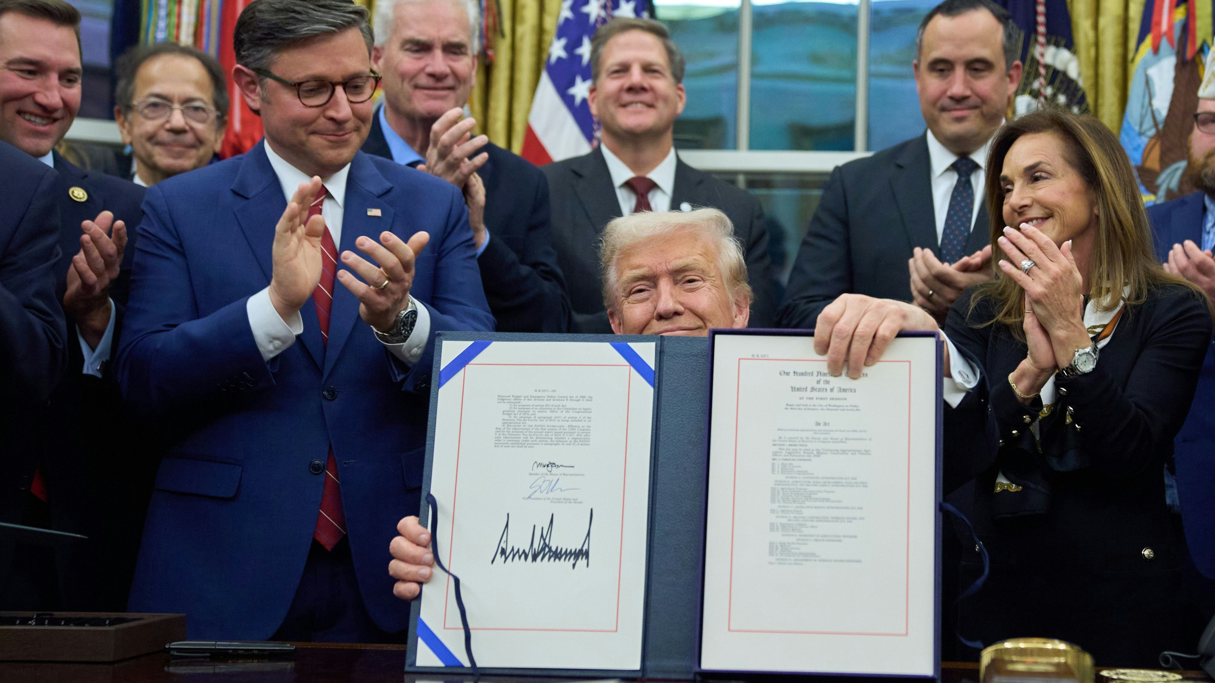 President Donald Trump displays the signed the funding bill to reopen the government, in the Oval Office of the White House, Wednesday, Nov. 12, 2025, in Washington. (AP Photo/Jacquelyn Martin)