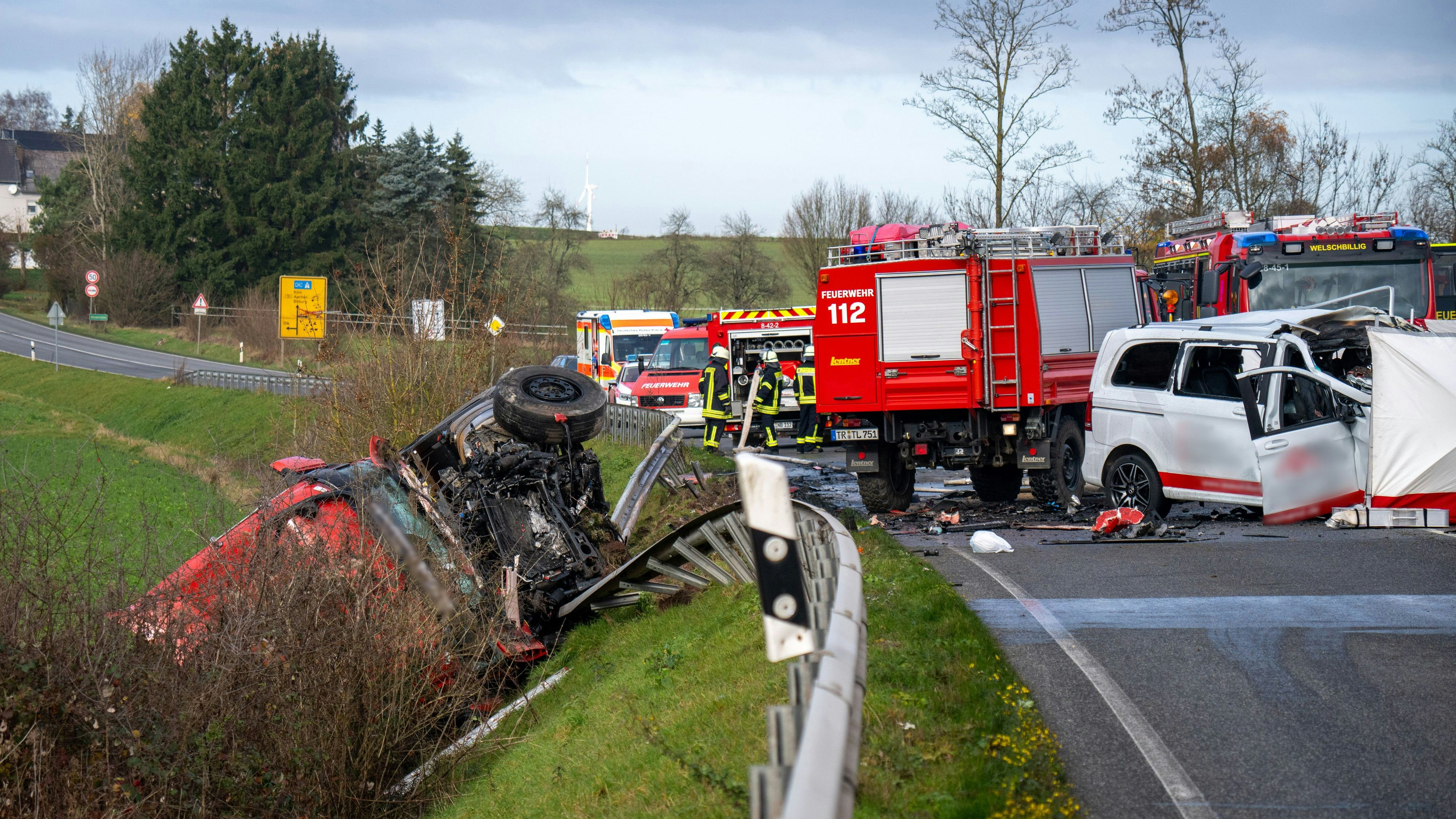 18 November 2025, Rhineland-Palatinate, Welschbillig-Windmühle: A truck lies behind the crash barrier on a slope on the B51 near Welschbillig after a head-on collision with a minibus (r). The section of the B51 in question is currently closed in both directions. Photo: Harald Tittel/dpa - ATTENTION: The minibus has been pixelated for legal reasons
