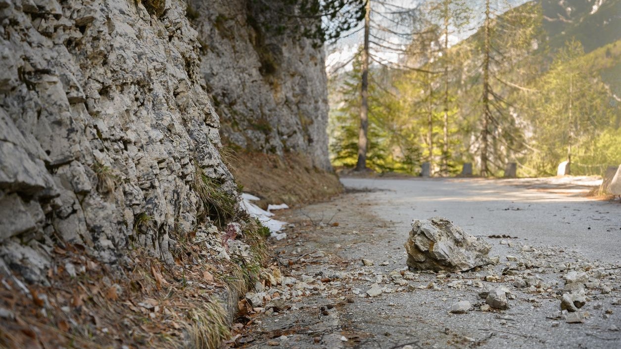 Forest road is blocked by a rocks and debris. Dangerous mountain road. Take caution.