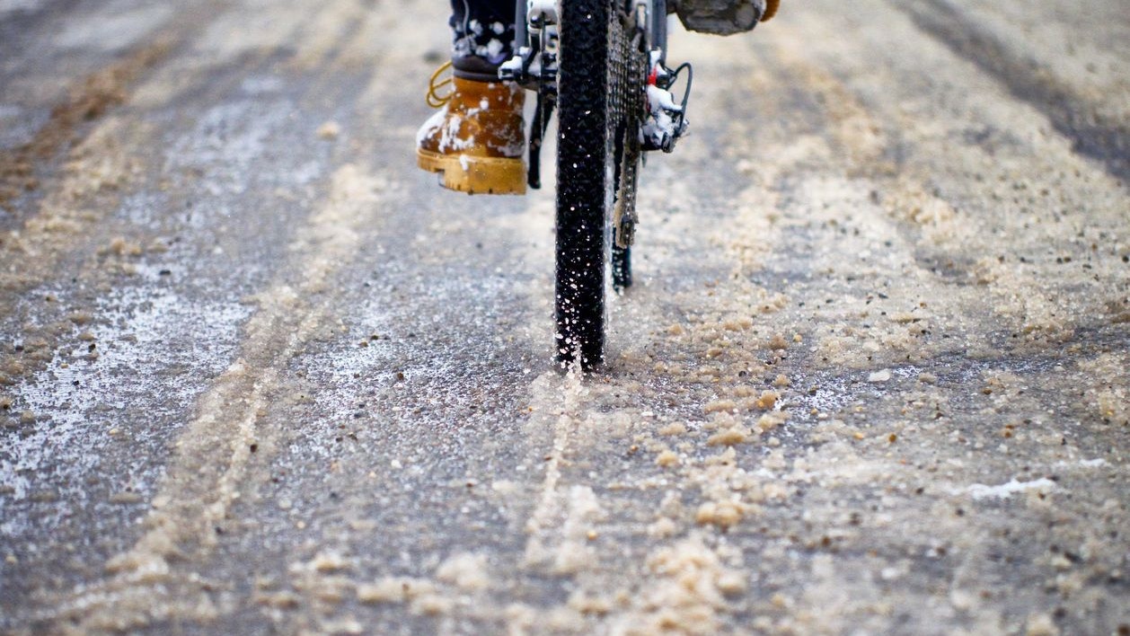 Biker on the road close up. Cloudy winter day. The road is in a small village in Romania. Film look image effect.