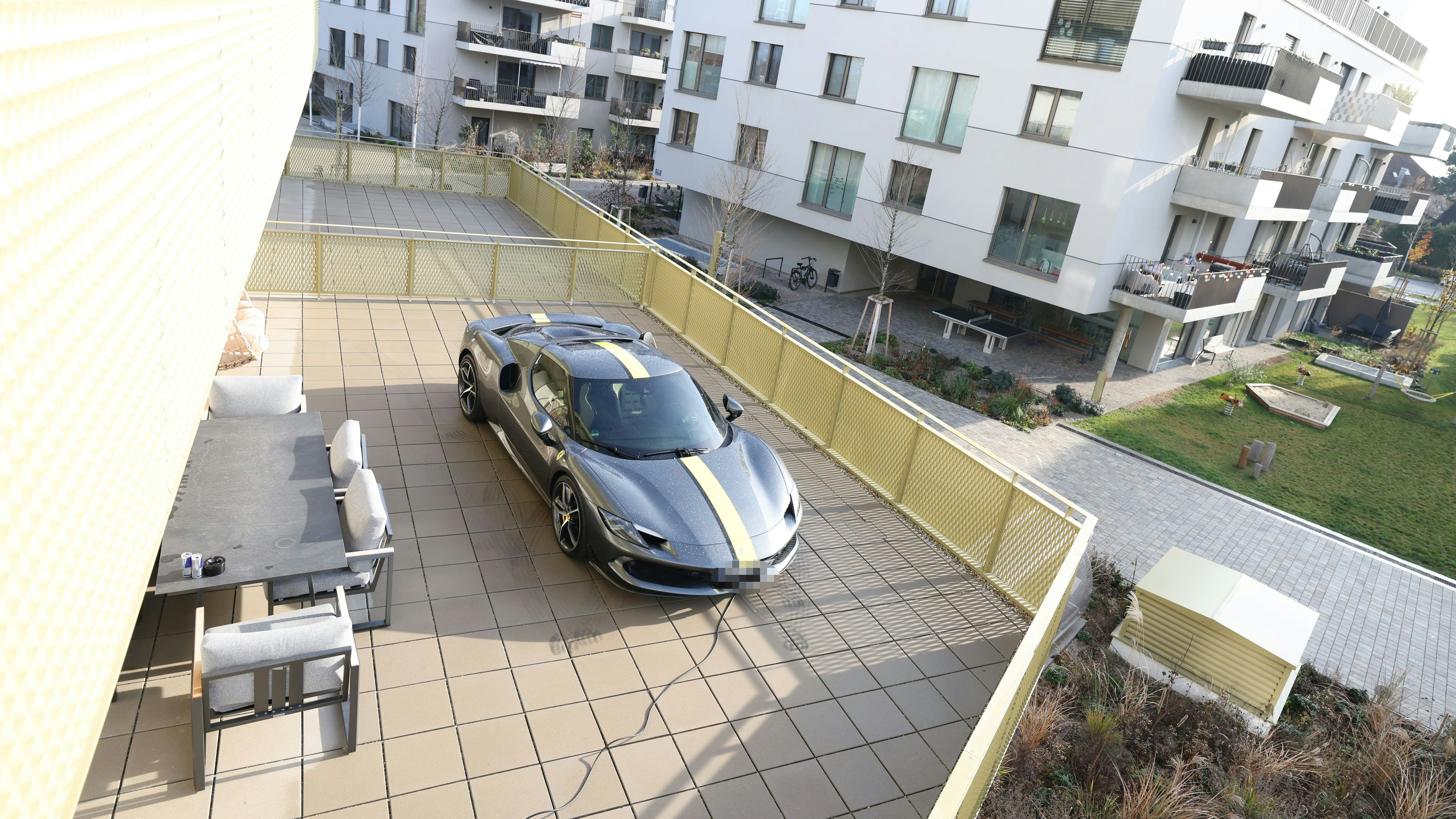 Mann lässt sich Ferrari in Wien auf Terrasse stellen