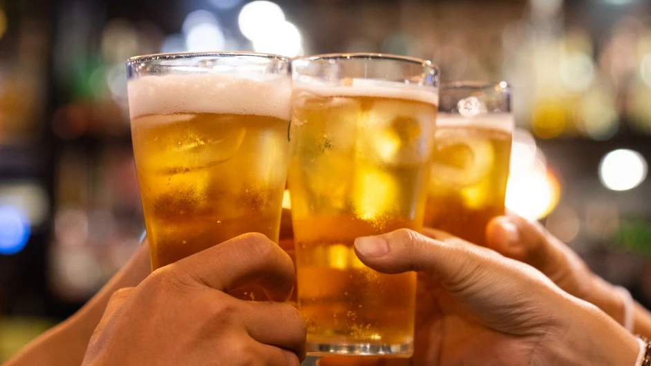 Group of happy friends drinking and toasting beer at brewery bar restaurant - Friendship concept with young people having fun together at cool vintage pub - Focus on middle pint glass