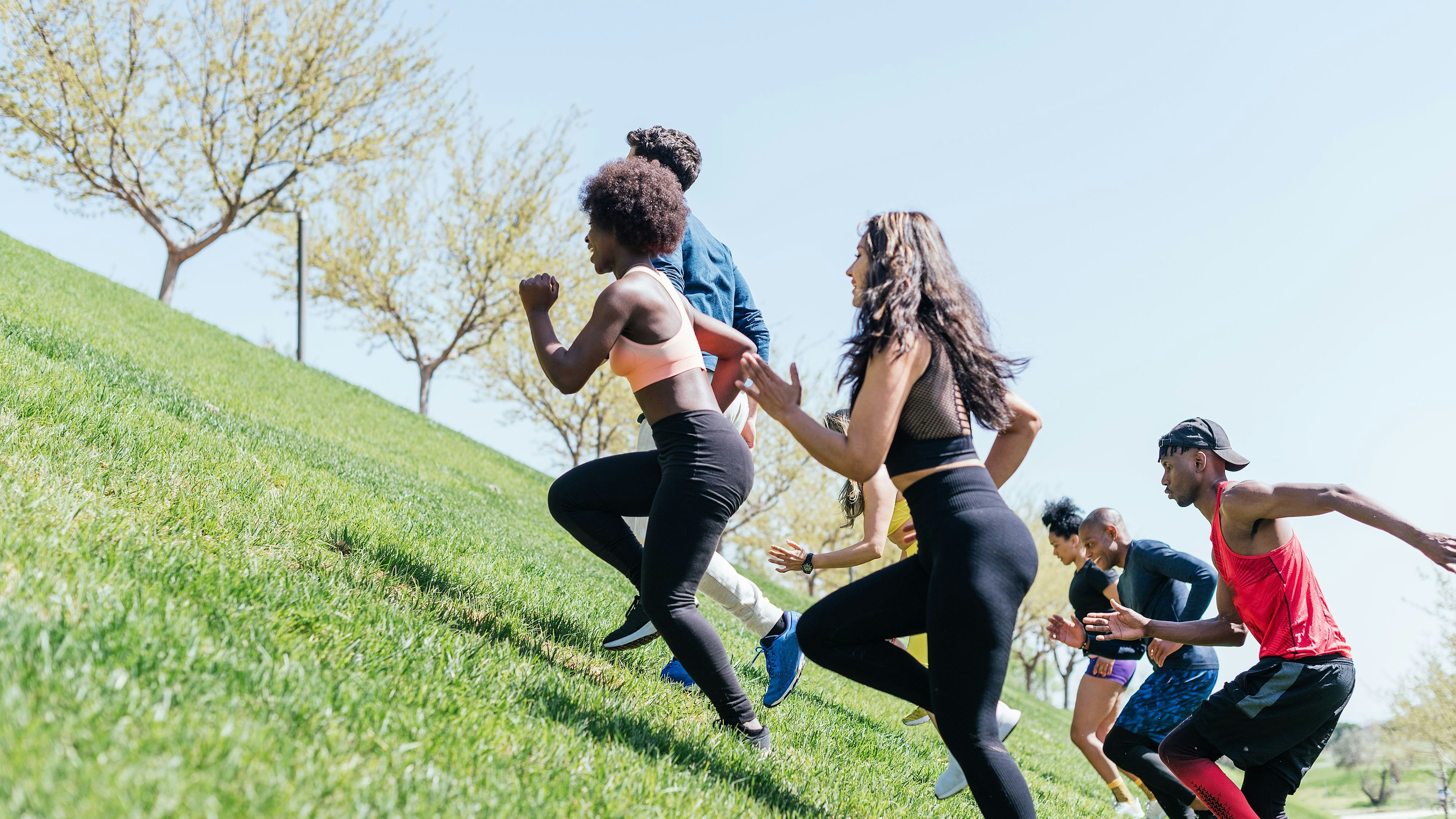 Group of runners running up a hill. Horizontal framing.