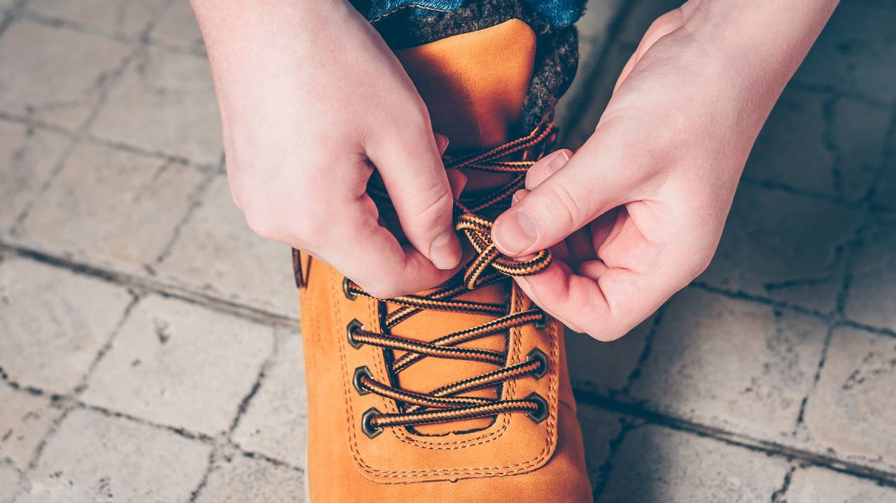 The boy is wearing hiking boots for walking and traveling, fees in a journey for adventure