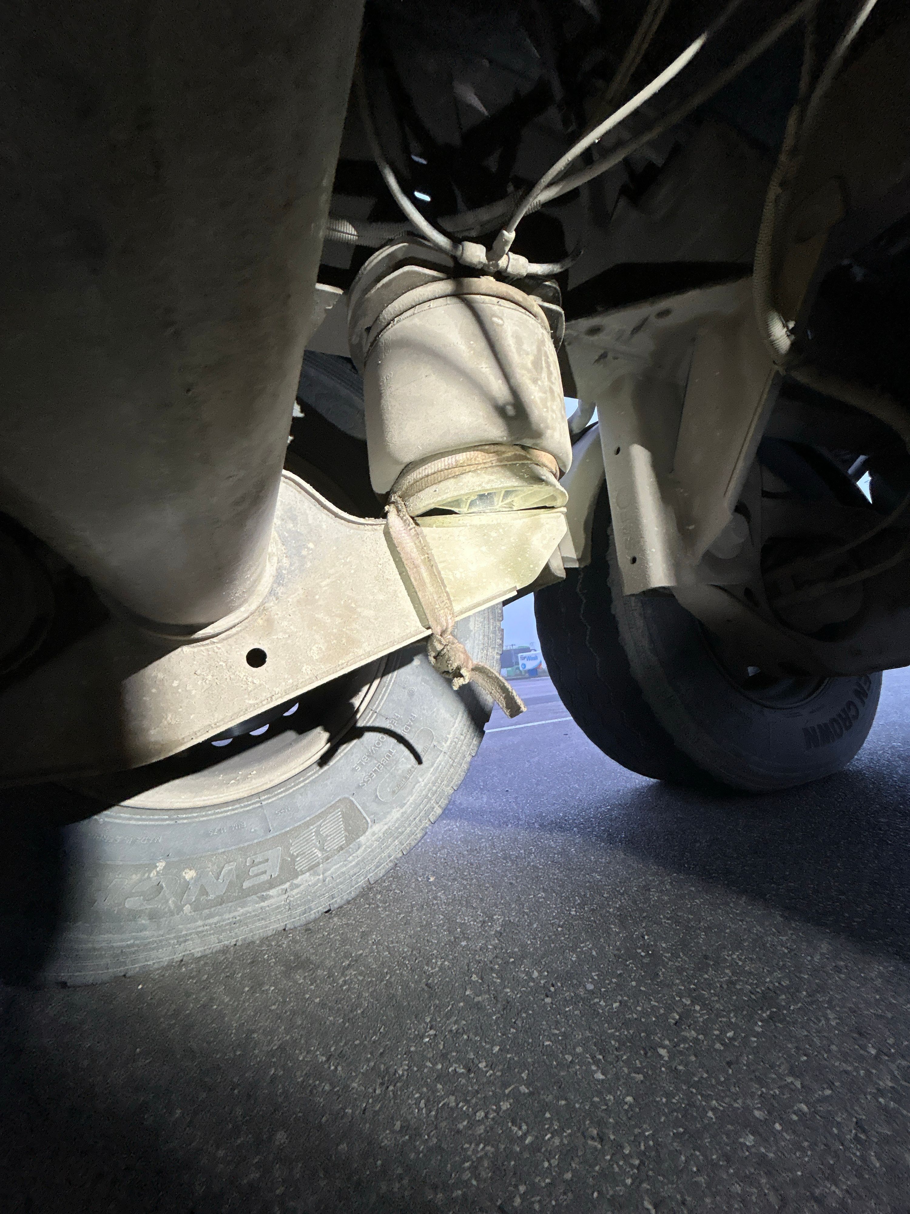 Der Luftbalg der dritten Achse rechts war mit einem Zurrgurt am Rahmen befestigt, da dieser defekt war.