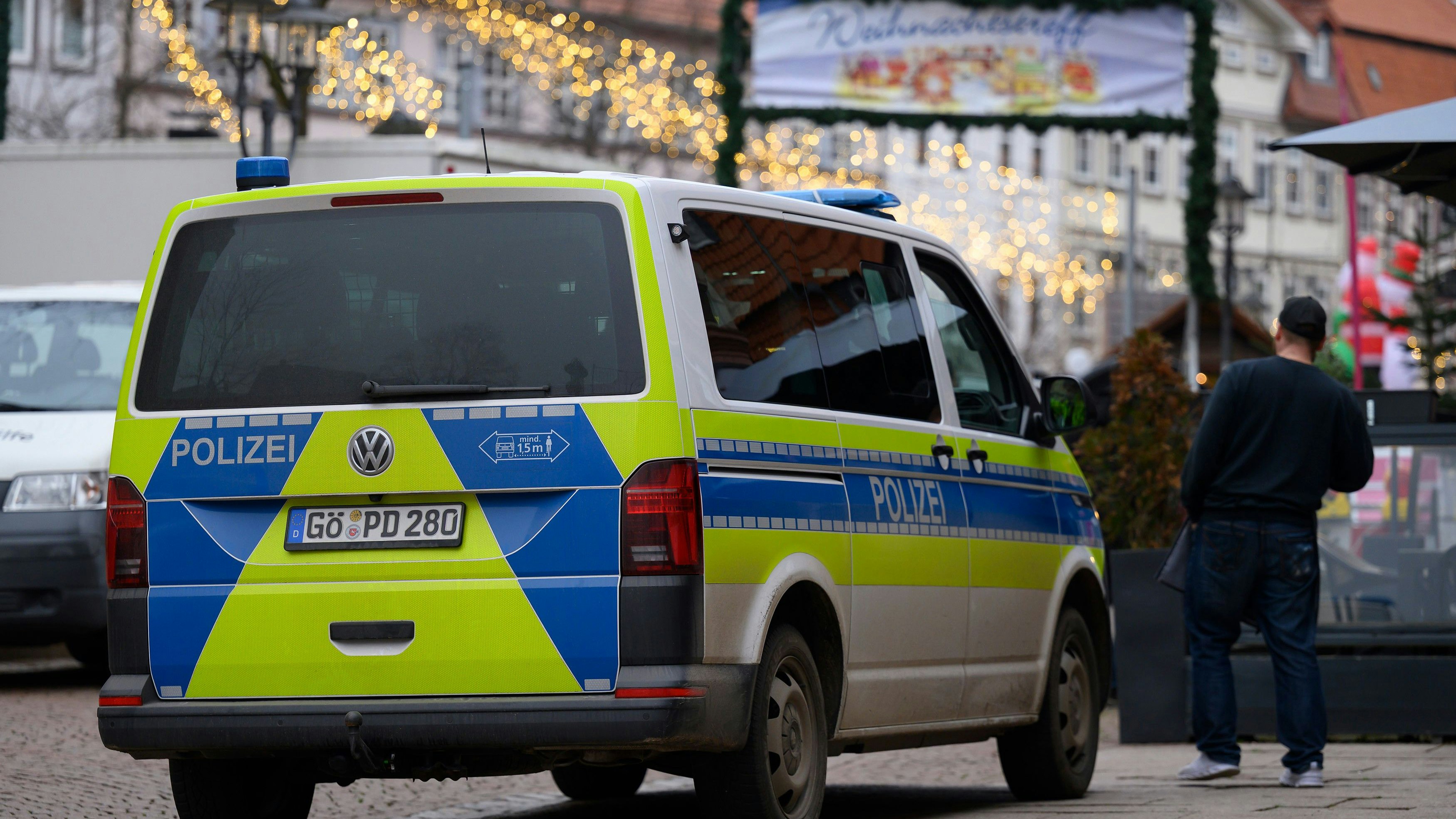 13 December 2025, Lower Saxony, Duderstadt: Police officers stand at the Christmas market. Following the evacuation of the Christmas market on 12.12.2025 in Duderstadt in southern Lower Saxony, the police are still looking for a suspect. Several witnesses claimed to have seen a man with a long gun on Friday evening. Photo: Swen Pförtner/dpa
