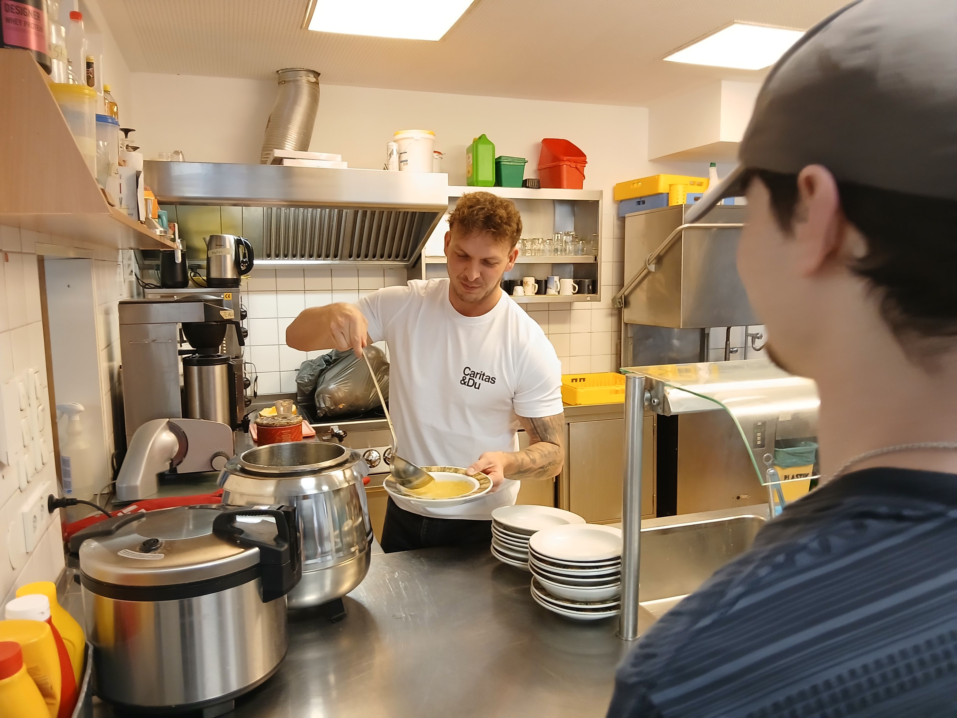 Patrick Hörtnagl gibt in der Linzer Caritas-Wärmestube wohltuendes Essen aus.