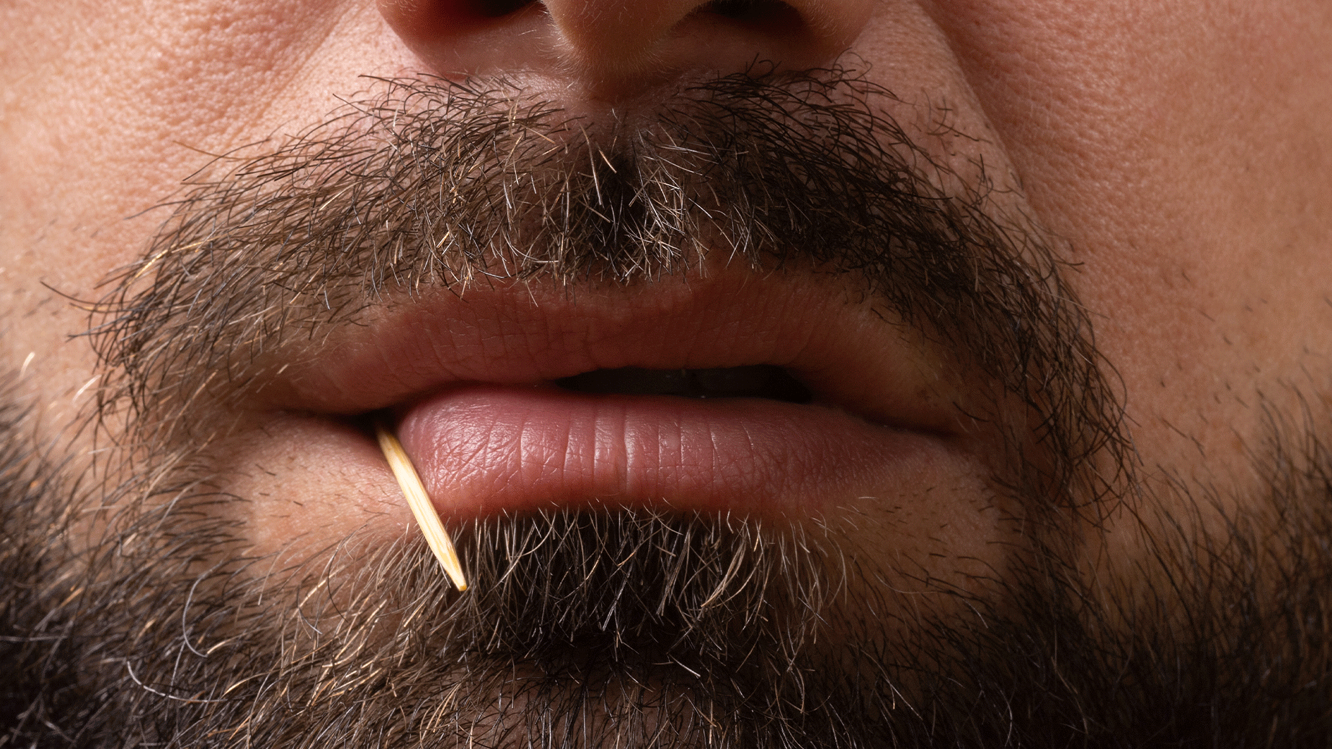 Mann mit Zahnstocher im Mund...