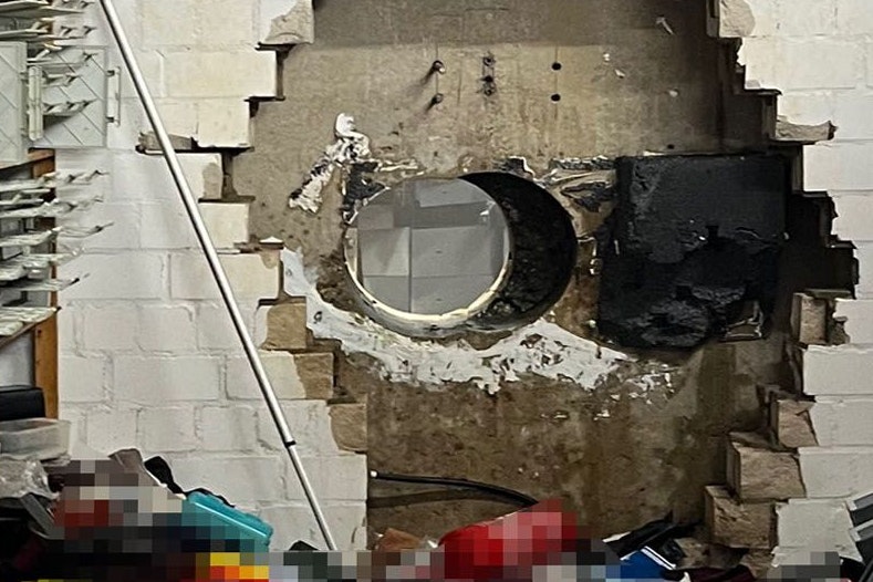 Detailaufnahme der beiden nebeneinander liegenden Bohrlöcher, dahinter kann man einige der aufgebrochenen Schließfachtüren erkennen