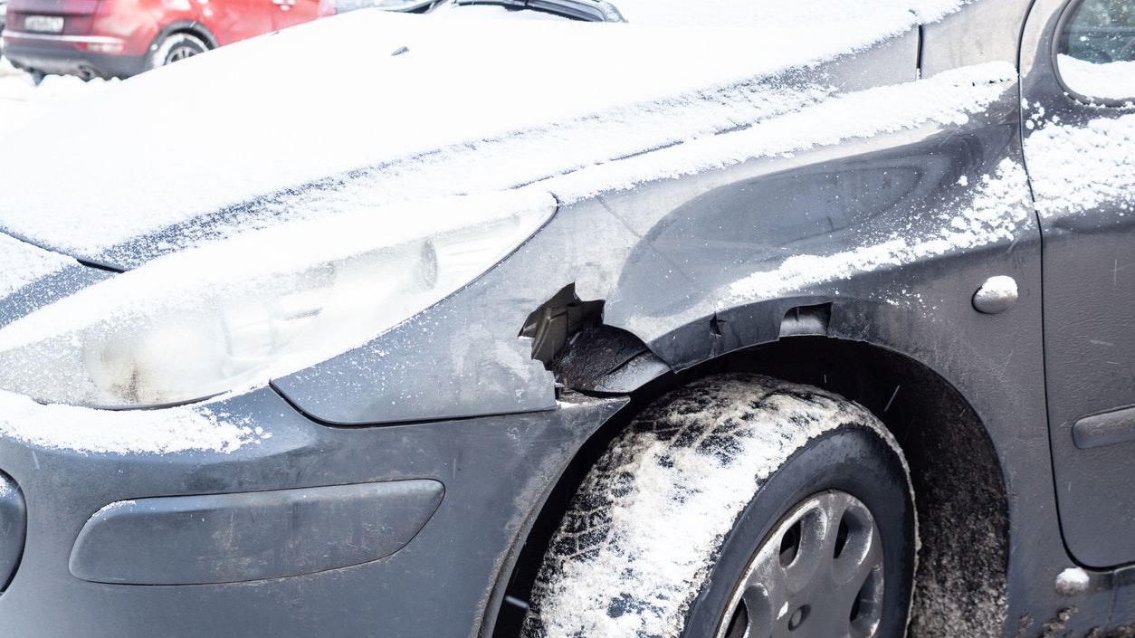 Gray car after an accident in winter with a hole in the wing