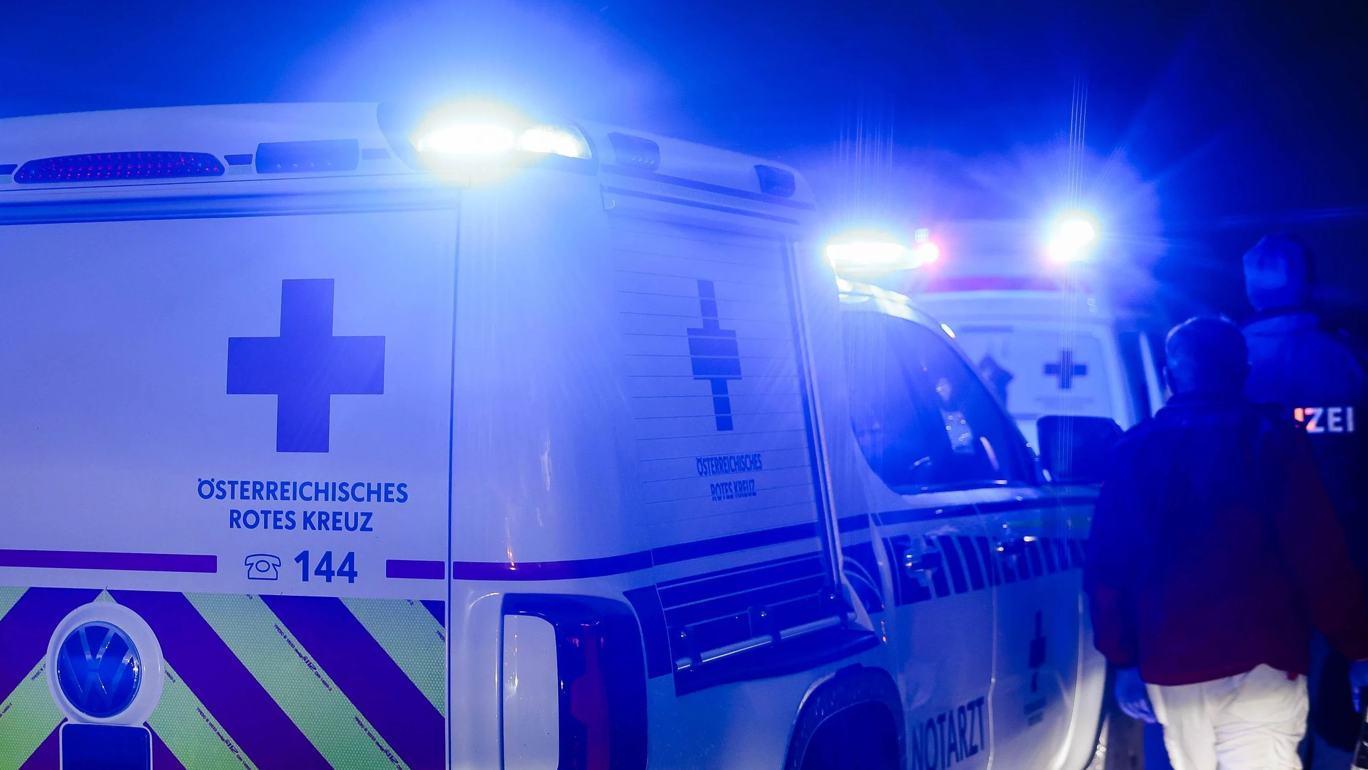 01.10.2024, Burgkirchen, AUT, Unterwegs in Oberösterreich, Symbolbild, Themenbild, Verschiedene Themenbilder, Unfall, Einsatzkräfte, Polizei, Rettung, Notarzt, Feuerwehr, im Bild Einsatzwagen, Notarzt, Erste Hilfe, Notarztwagen, Das Bild zeigt ein Notarzt-Einsatzfahrzeug des Rettungsdienstes in Oberösterreich vom Stützpunkt Braunau. Das Fahrzeug ist ein weißer Volkswagen mit auffälligen rot-gelben Markierungen und einem beleuchteten Blaulicht. Es ist auf einer Landstraße bei Regen zu sehen, Landstraße, Regen, Abenddämmerung, Unfallstelle, Rettung, Erste Hilfe, *** 01 10 2024, Burgkirchen, AUT, On the road in Upper Austria, symbol picture, theme picture, various theme pictures, accident, emergency services, police, rescue, emergenc