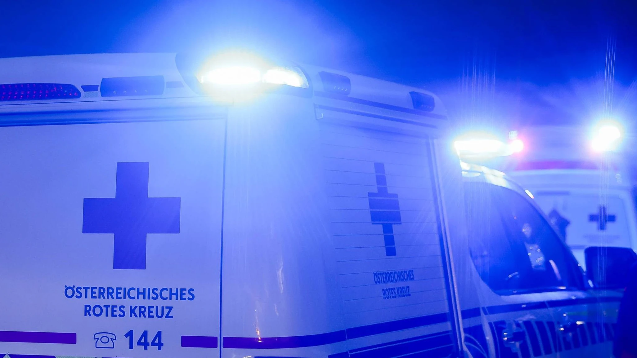 01.10.2024, Burgkirchen, AUT, Unterwegs in Oberösterreich, Symbolbild, Themenbild, Verschiedene Themenbilder, Unfall, Einsatzkräfte, Polizei, Rettung, Notarzt, Feuerwehr, im Bild Einsatzwagen, Notarzt, Erste Hilfe, Notarztwagen, Das Bild zeigt ein Notarzt-Einsatzfahrzeug des Rettungsdienstes in Oberösterreich vom Stützpunkt Braunau. Das Fahrzeug ist ein weißer Volkswagen mit auffälligen rot-gelben Markierungen und einem beleuchteten Blaulicht. Es ist auf einer Landstraße bei Regen zu sehen, Landstraße, Regen, Abenddämmerung, Unfallstelle, Rettung, Erste Hilfe, *** 01 10 2024, Burgkirchen, AUT, On the road in Upper Austria, symbol picture, theme picture, various theme pictures, accident, emergency services, police, rescue, emergenc