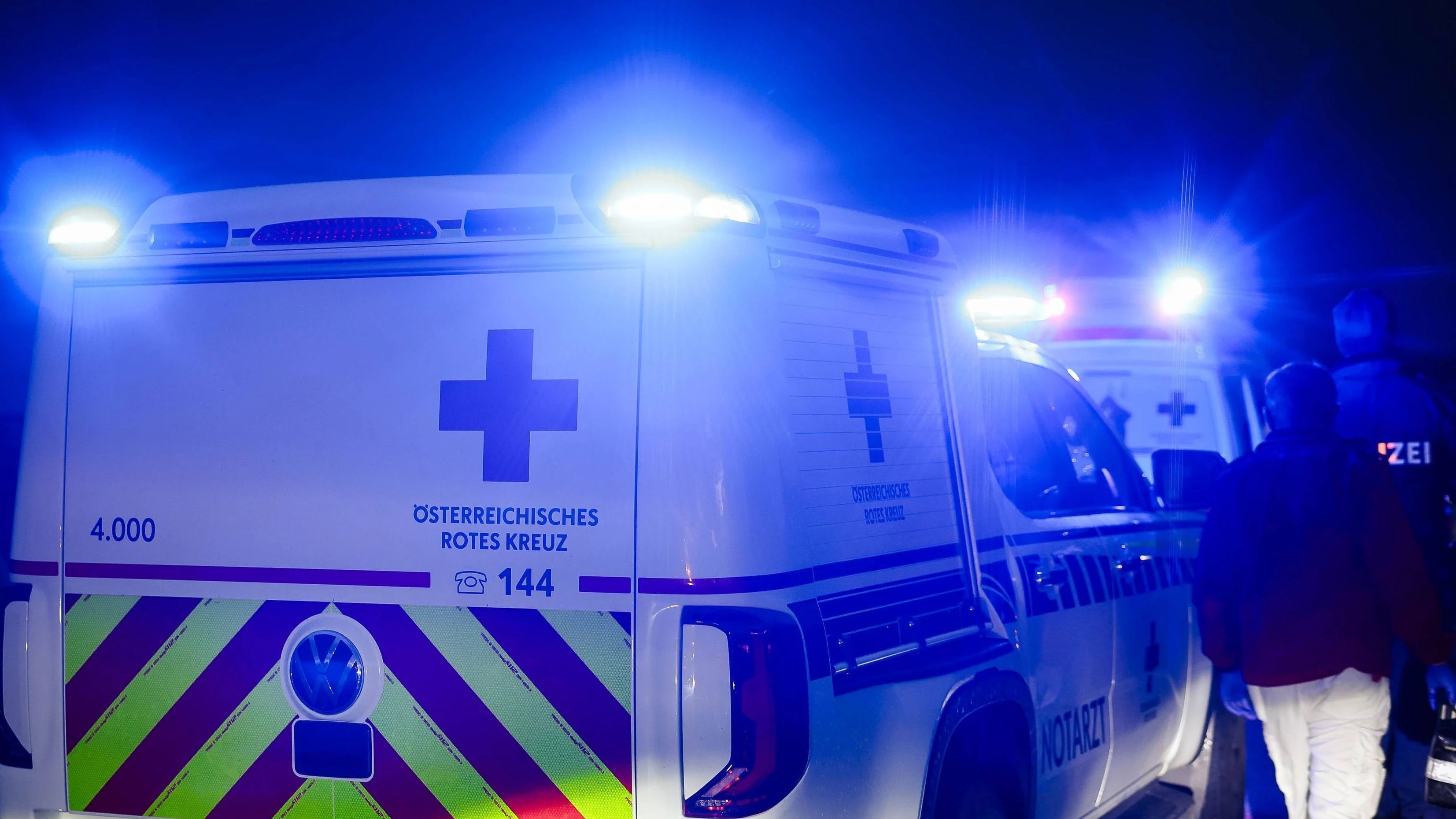 01.10.2024, Burgkirchen, AUT, Unterwegs in Oberösterreich, Symbolbild, Themenbild, Verschiedene Themenbilder, Unfall, Einsatzkräfte, Polizei, Rettung, Notarzt, Feuerwehr, im Bild Einsatzwagen, Notarzt, Erste Hilfe, Notarztwagen, Das Bild zeigt ein Notarzt-Einsatzfahrzeug des Rettungsdienstes in Oberösterreich vom Stützpunkt Braunau. Das Fahrzeug ist ein weißer Volkswagen mit auffälligen rot-gelben Markierungen und einem beleuchteten Blaulicht. Es ist auf einer Landstraße bei Regen zu sehen, Landstraße, Regen, Abenddämmerung, Unfallstelle, Rettung, Erste Hilfe, *** 01 10 2024, Burgkirchen, AUT, On the road in Upper Austria, symbol picture, theme picture, various theme pictures, accident, emergency services, police, rescue, emergenc