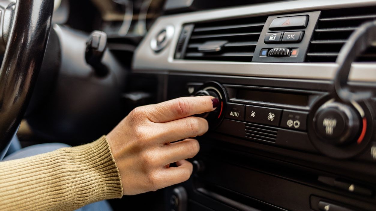 Woman turning button of radio in car