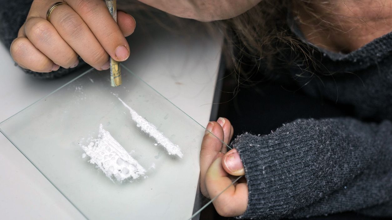 Young woman snorting drugs, cocaine or speed or other drugs abuse, addiction and depression