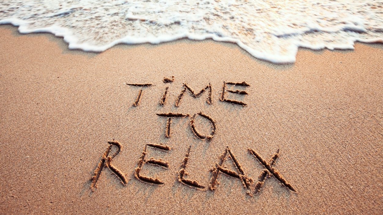 time to relax, concept written on sandy beach